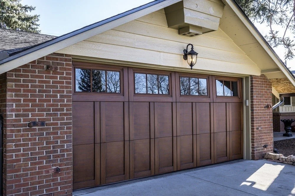 brick home with a brown wood garage door