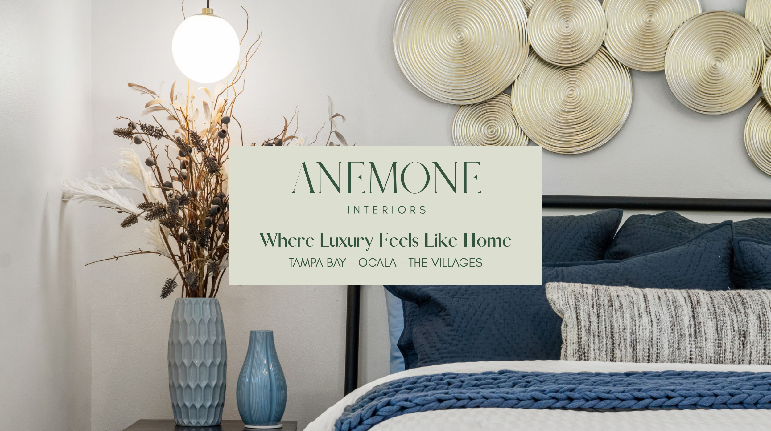 Modern bedroom design by Anemone Interiors with deep blue bedding, sculptural gold wall art, layered textiles, and cozy contemporary styling in a Florida home.