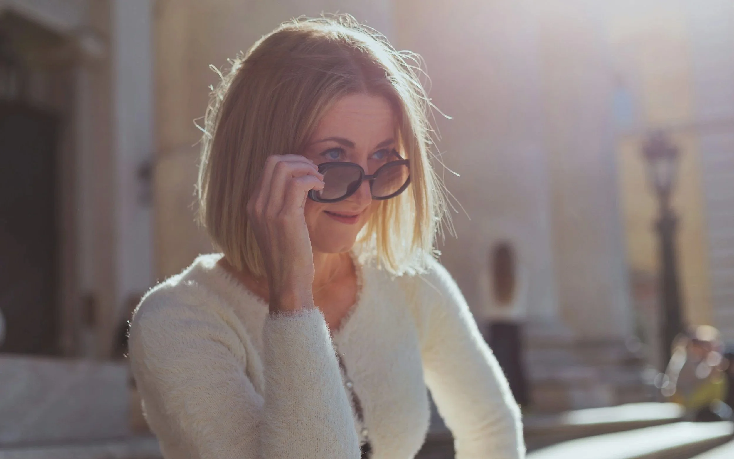 Woman wearing sunglasses sitting in autumn sunshine