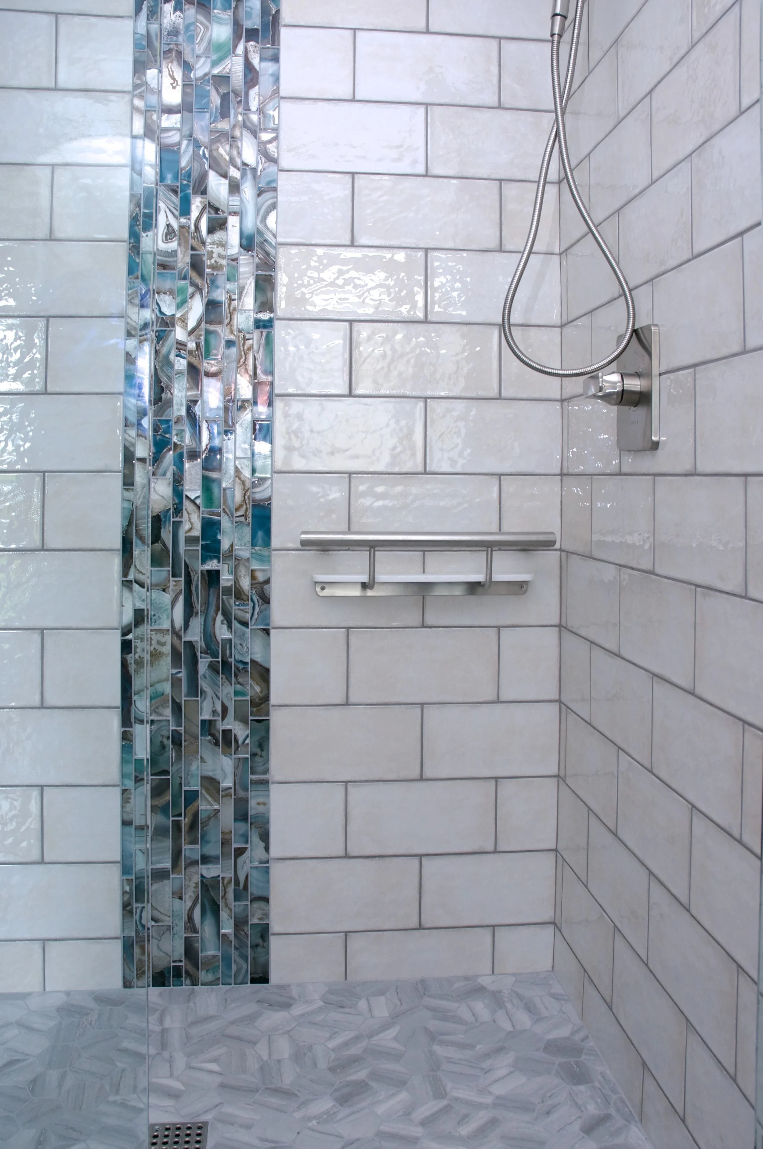 white tile shower with blue vertical strip