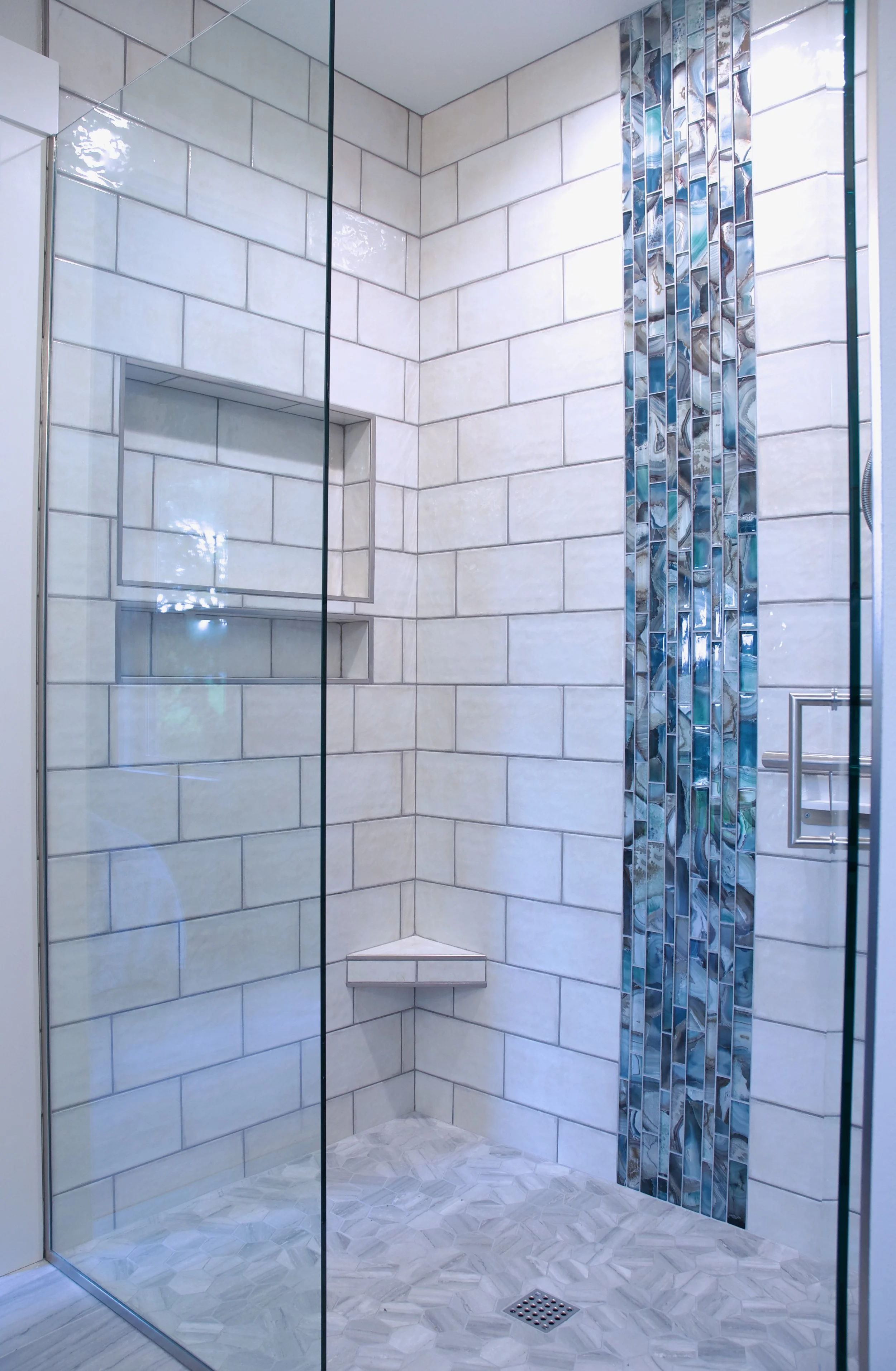 white tile shower with blue vertical strip