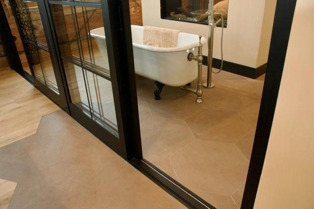Hexagon brown tile floor around clawsfoot tub