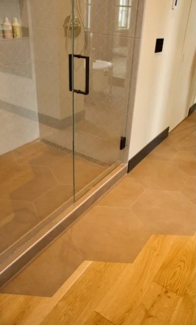 Hexagon brown tile floor blend in with wood floors and outside tile shower