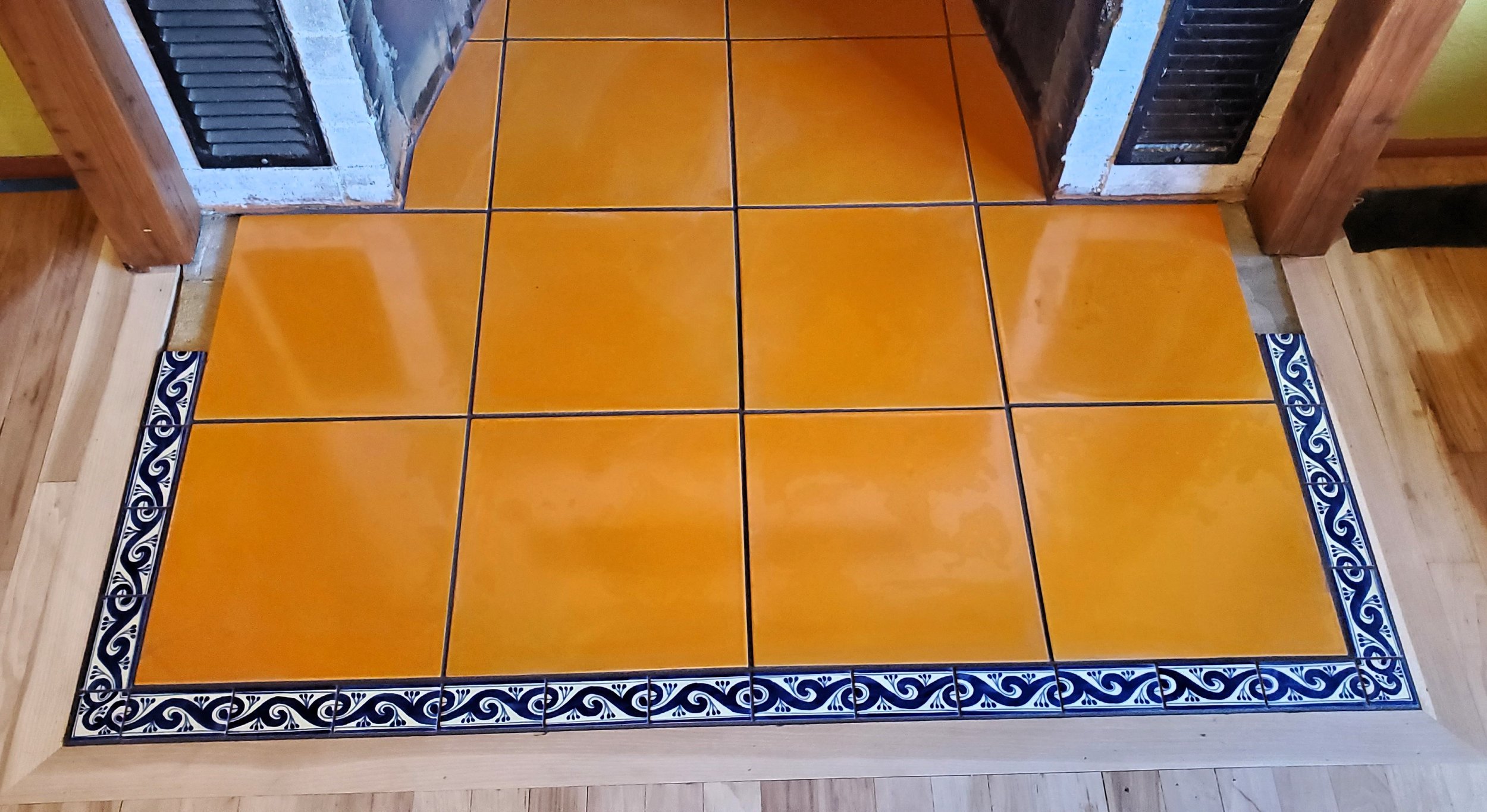 Orange tile with blue detail tile fireplace