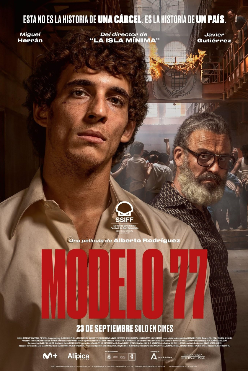Cartel de la película Modelo 77, con dos hombres en primer plano, uno joven y otro mayor, en un fondo de cárcel en llamas y personas protestando.