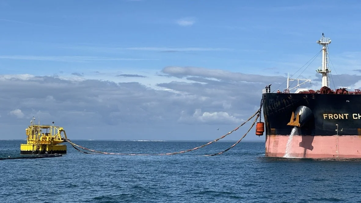 Barco grande y remolque en el mar, con cielo parcialmente nublado.