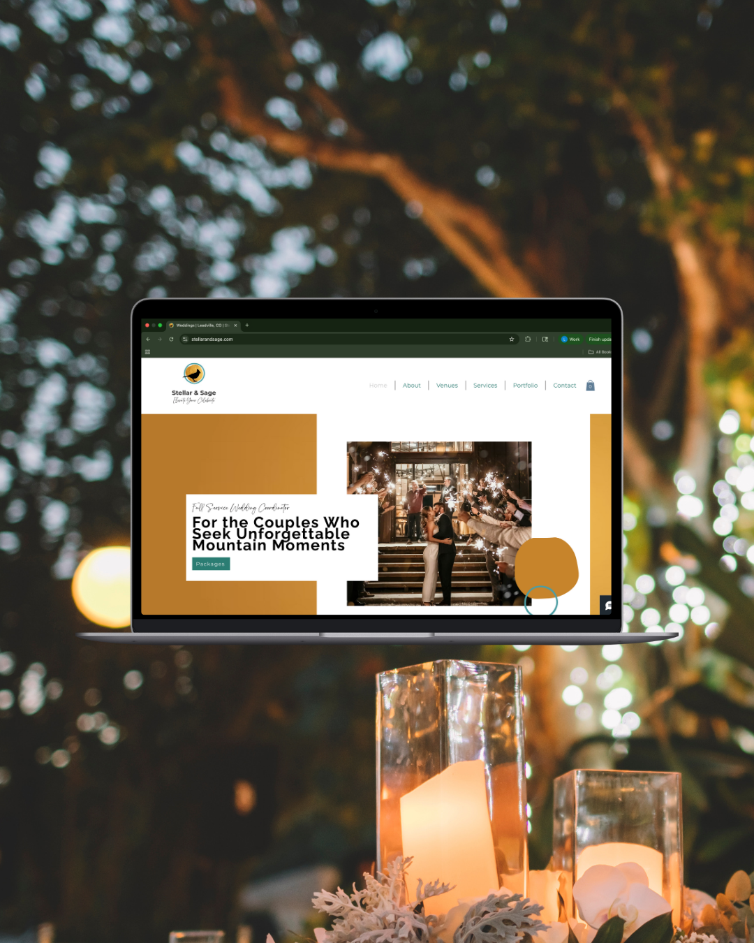 A laptop displaying a wedding website, placed on a table with candles and floral decorations outdoors at dusk.