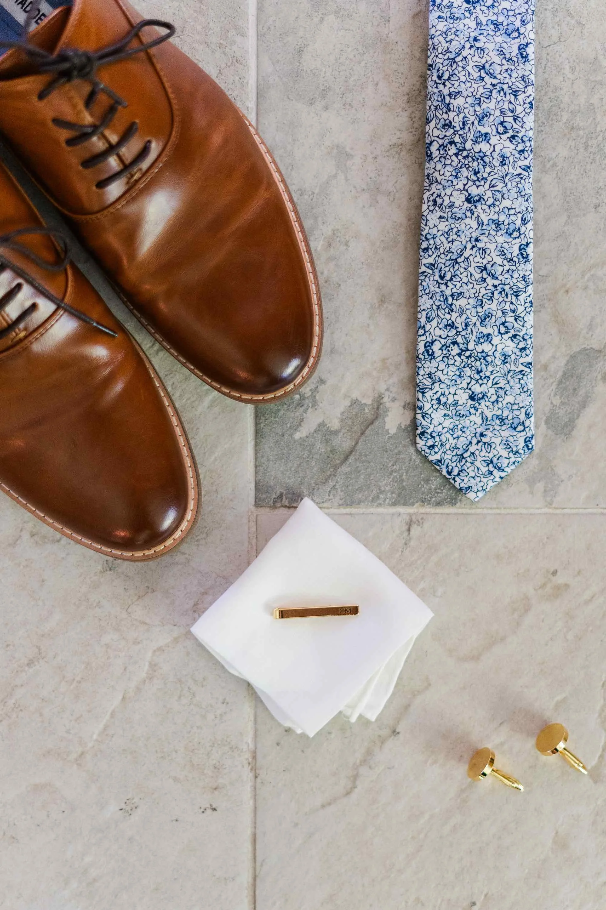 flat lay of wedding tie, shoes, and handkerchief