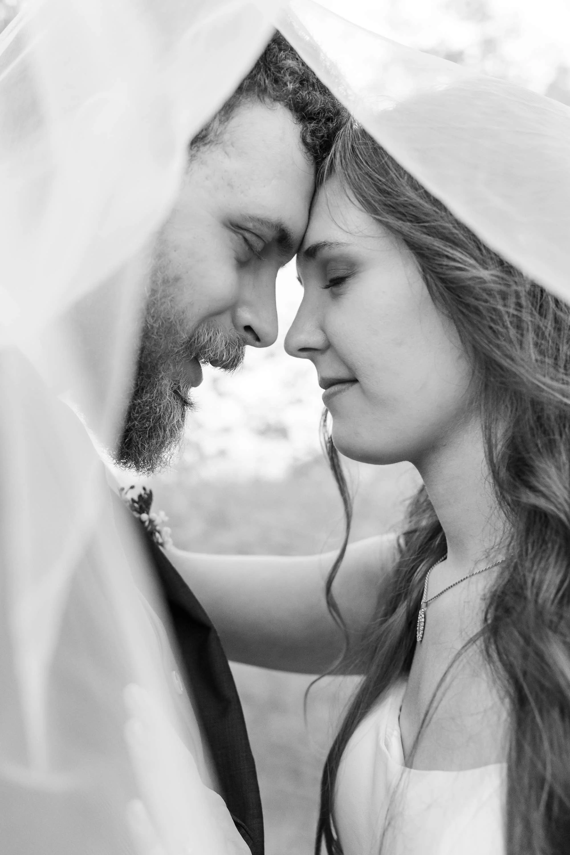 bride and groom with heads together under the brides veil