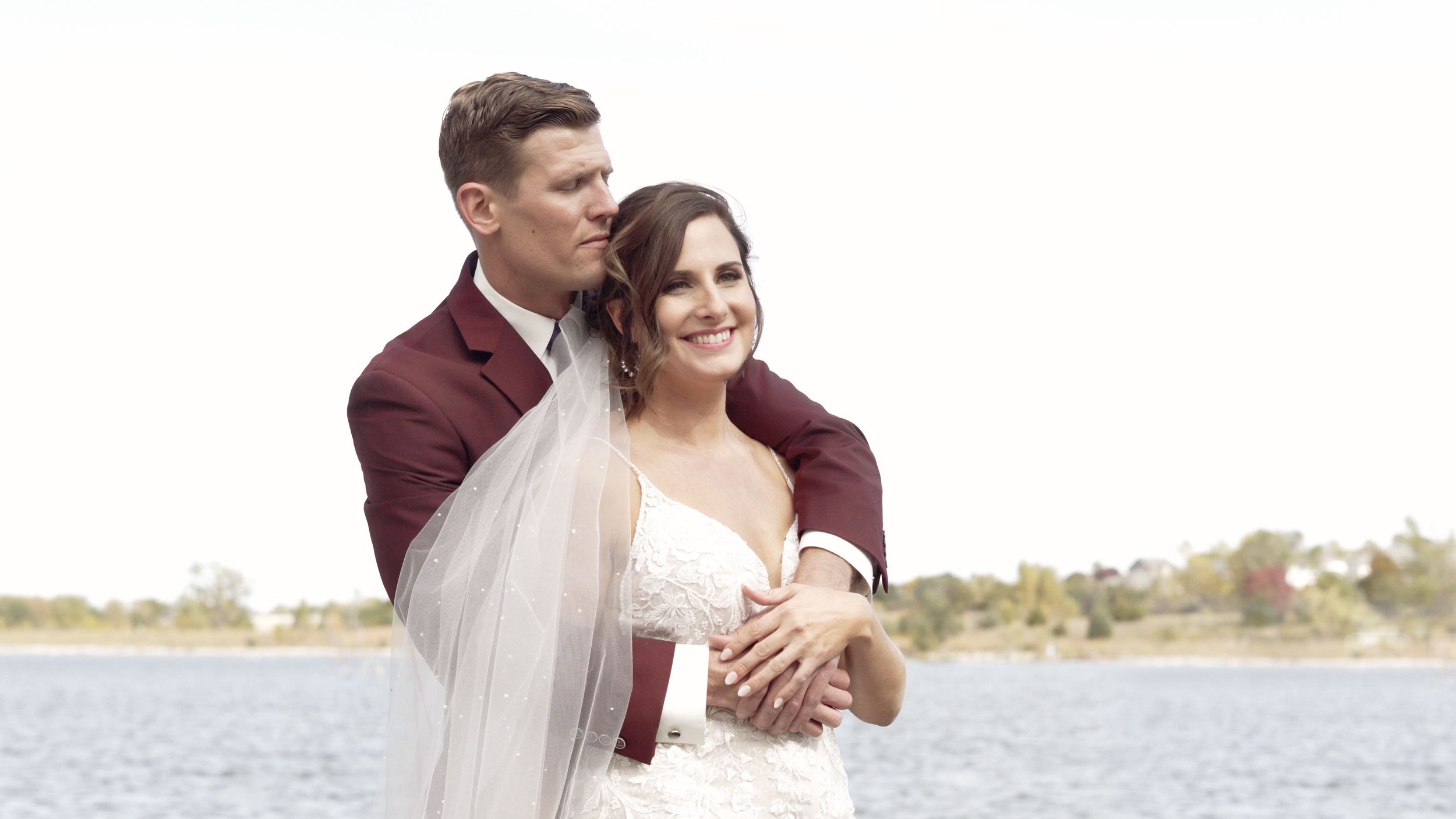 Bride and groom posing in front of a lake for a photo taken by Tess Sousek of Heart and Light Company