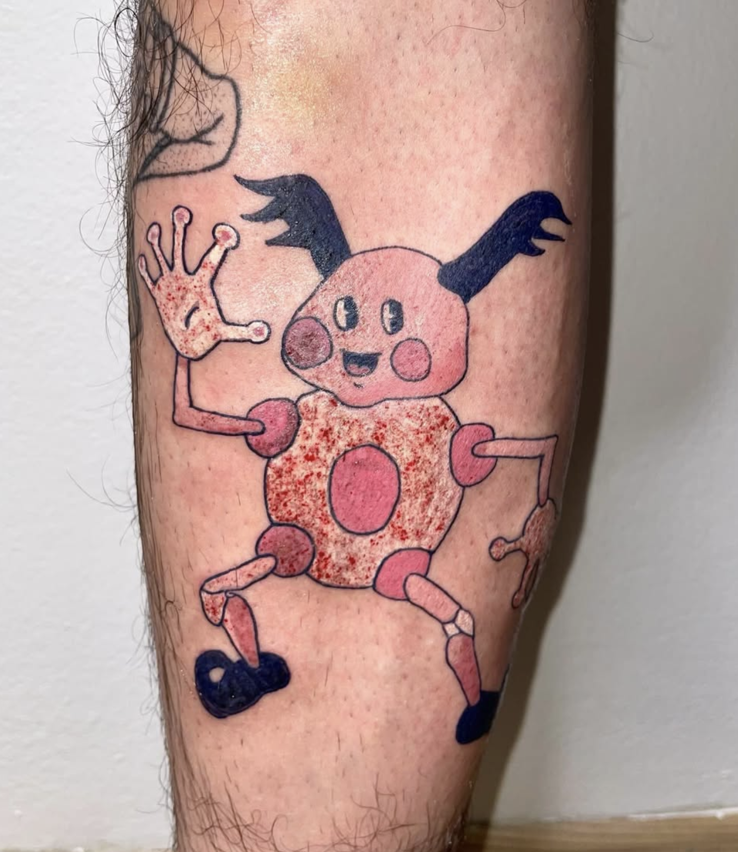 Tattoo eines lachenden Pikachu mit schwarzen Ohren und roten Wangen auf dem Unterarm.
