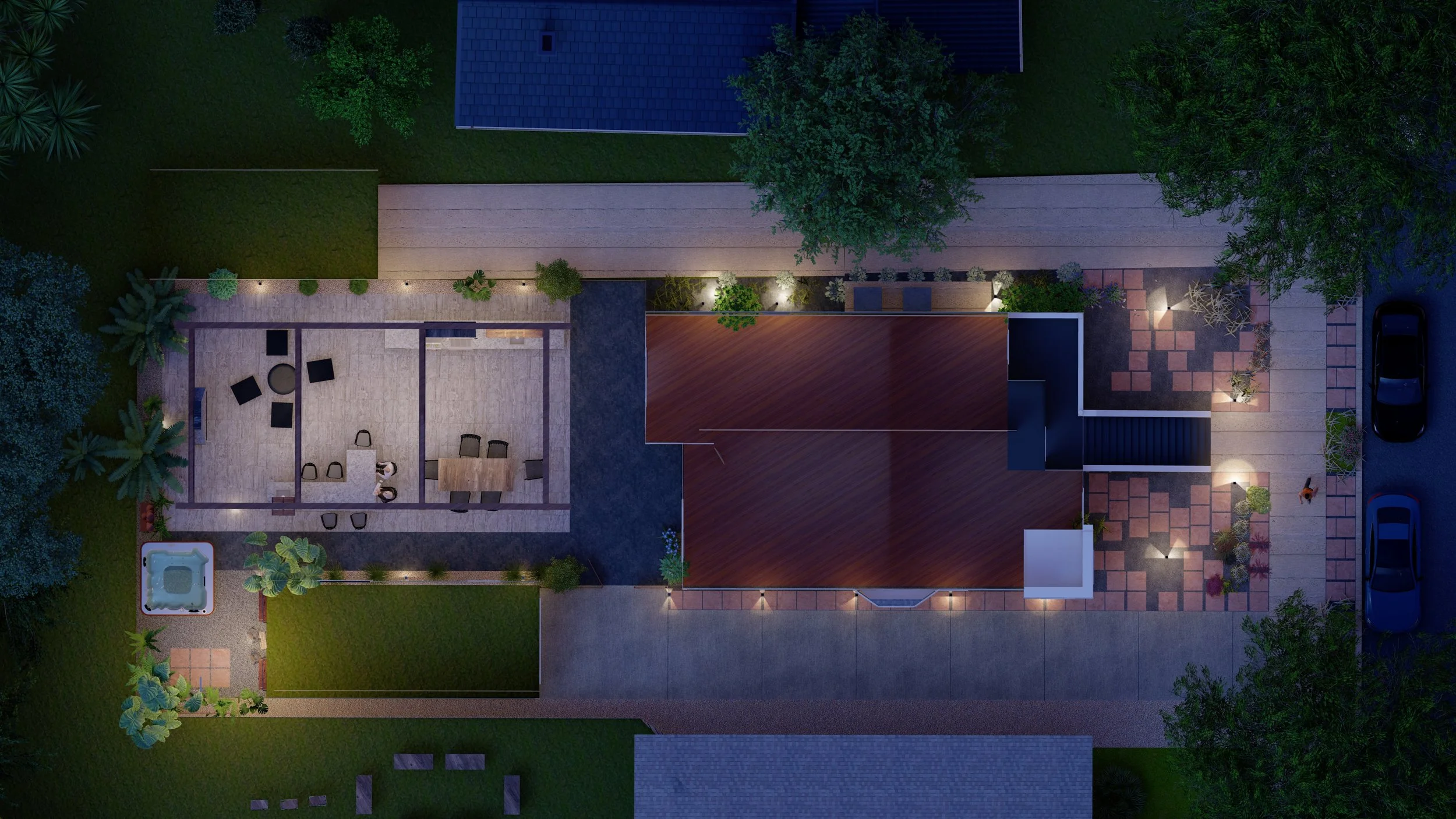 Overhead view of a backyard at night featuring a patio with outdoor furniture, a hot tub, a lawn, a modern house with a wooden deck, a paved walkway, and a driveway with parked cars, illuminated by outdoor lighting and surrounded by trees.