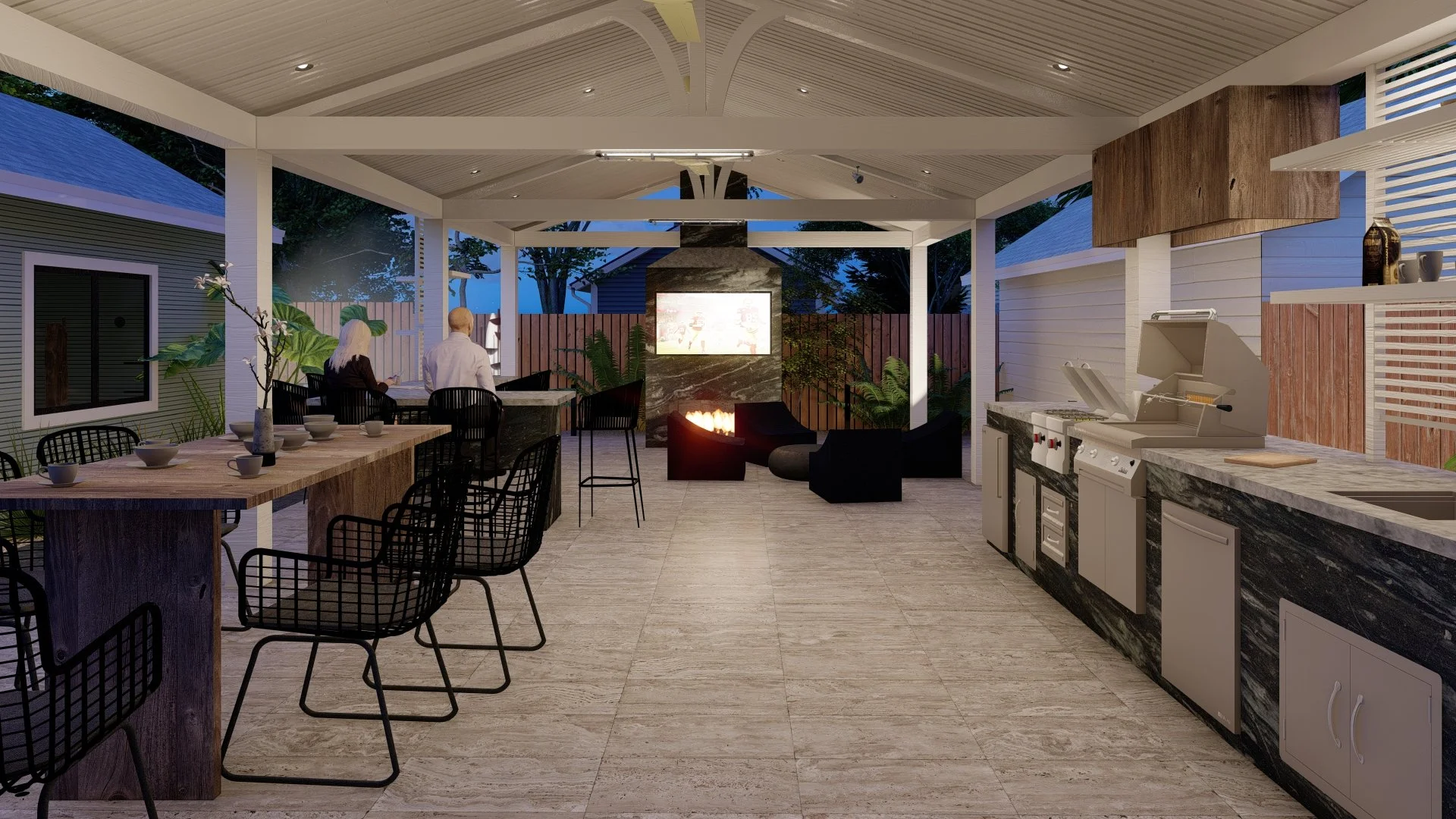 Indoor outdoor kitchen and lounge area with a dining table, bar stools, a fireplace, TV, and seating area, during evening with the outdoor view visible.