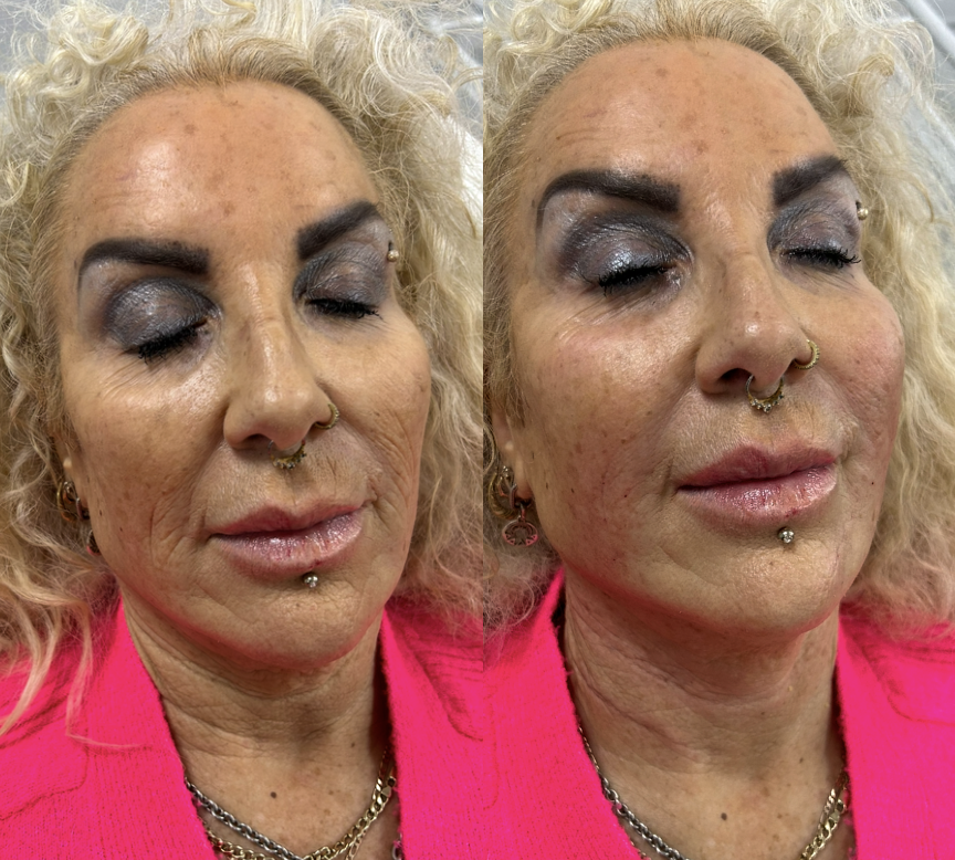 Close-up of a woman with blonde curly hair wearing bright pink clothing, dark makeup, and multiple facial piercings.