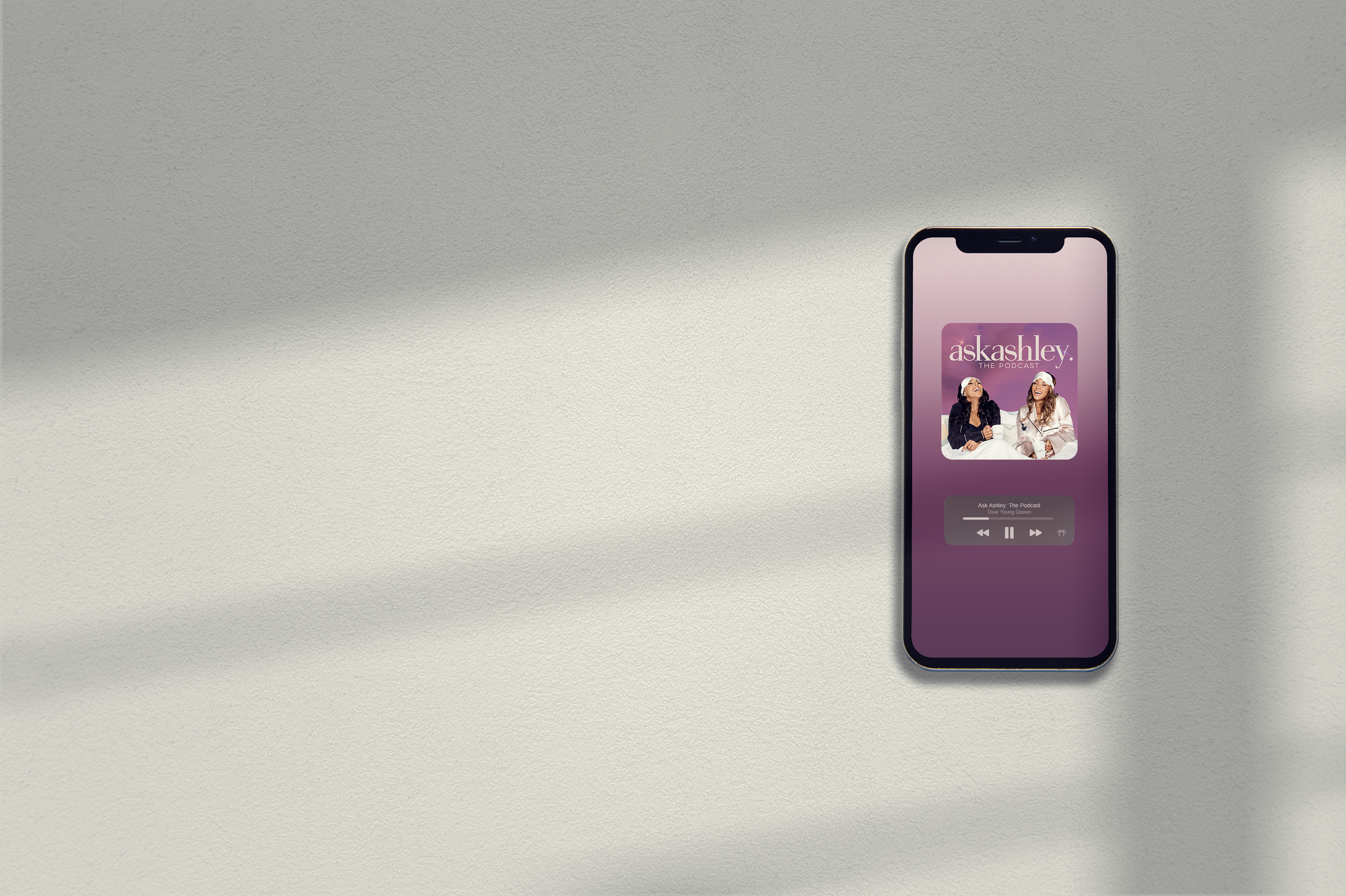 Smartphone displaying the podcast titled 'Ask Ashley' with two women on the cover.