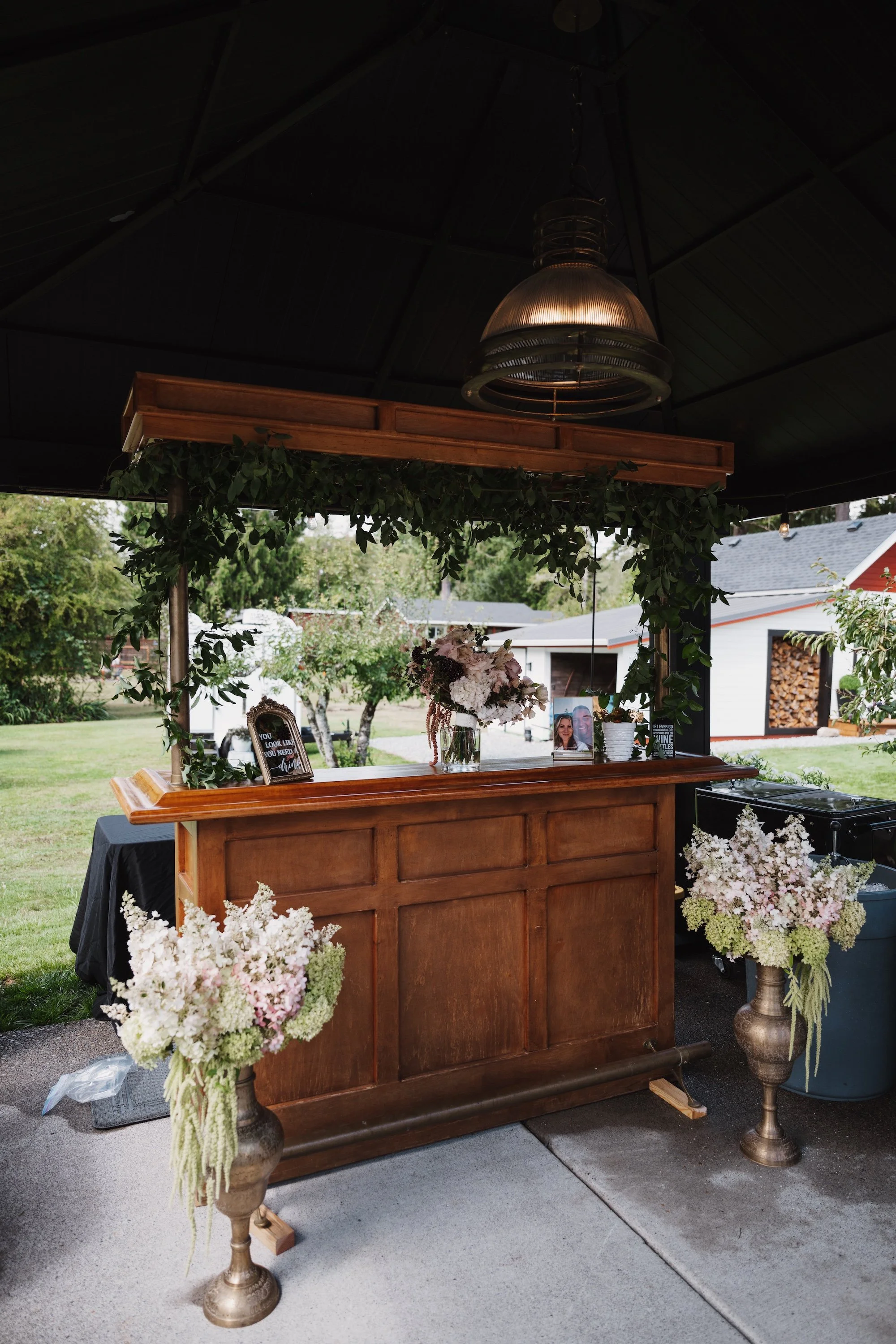 Wedding bar decorated with lush floral urns and greenery