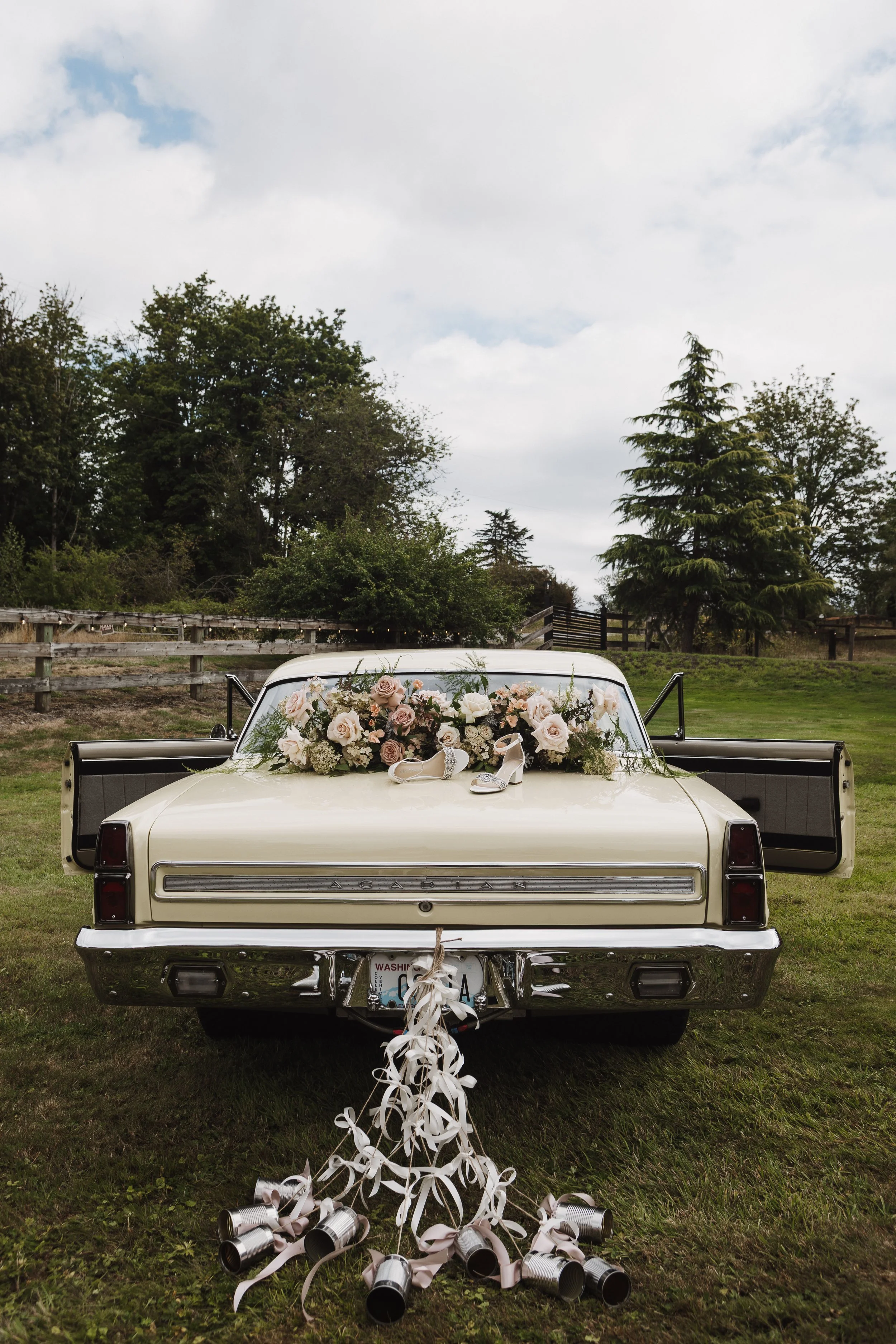 vintage car decorate with wedding flowers and tin cans