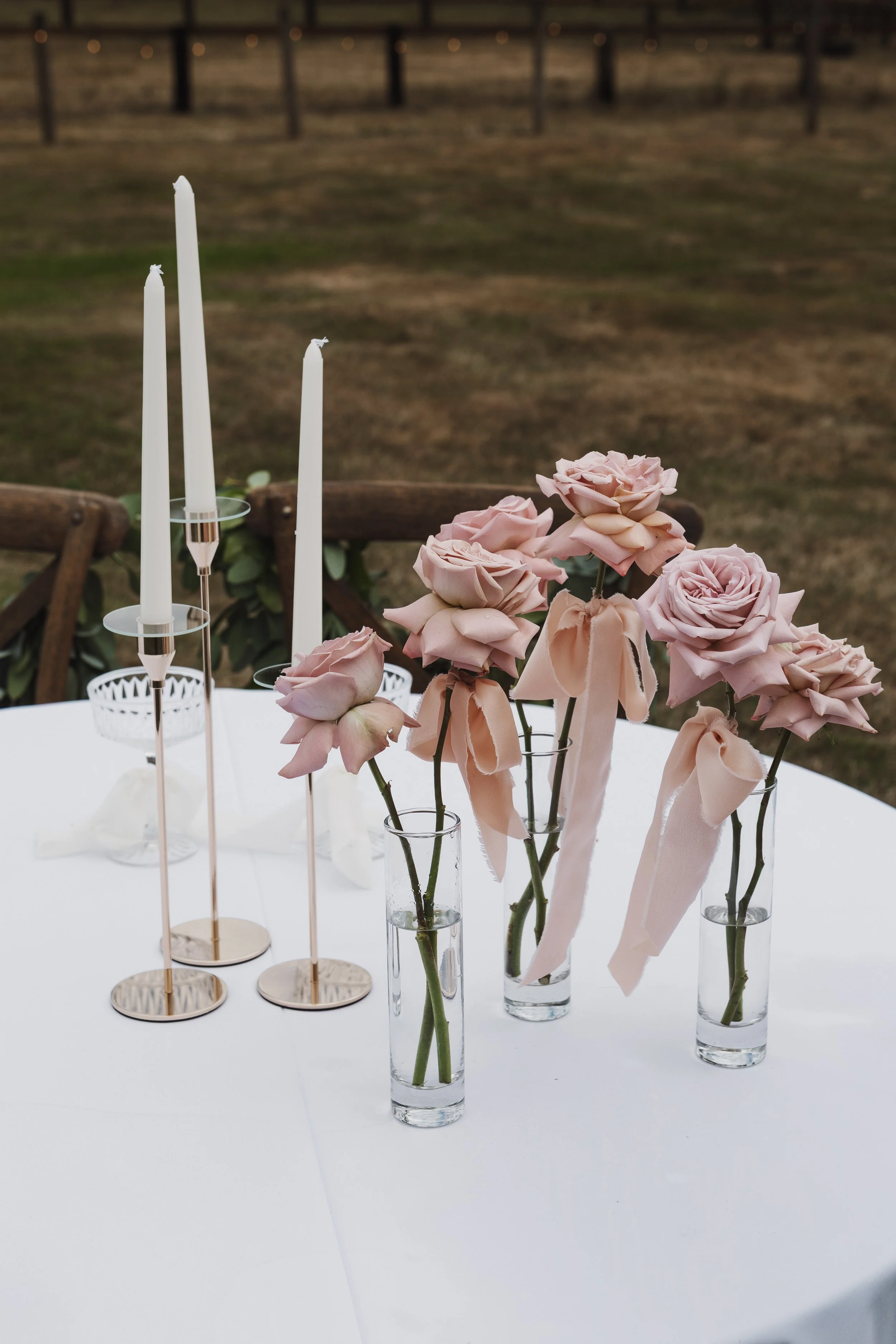 bud vases on reception table with mauve roses and ribbons