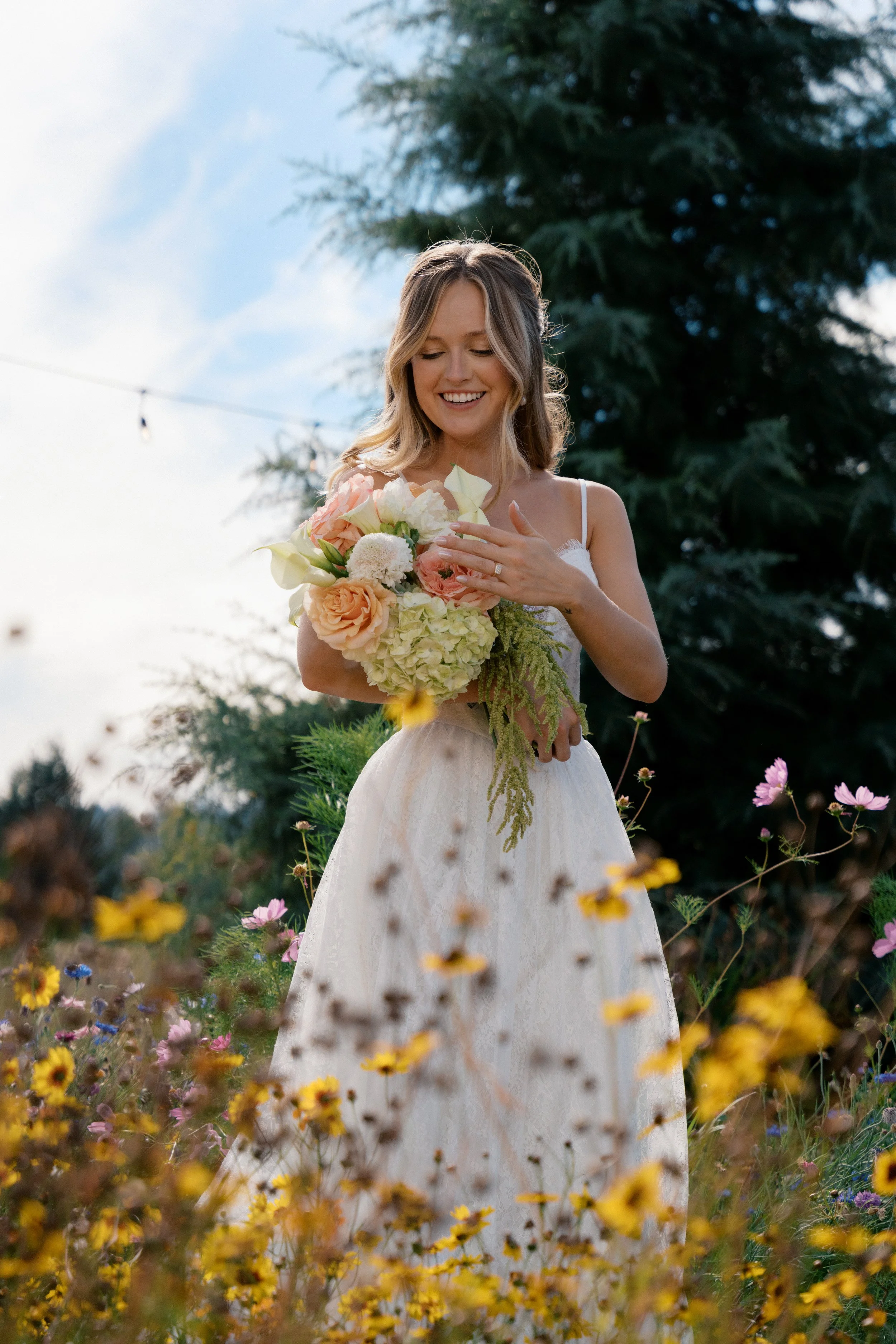 Bride in a field of wildflowers holding bridal bouq