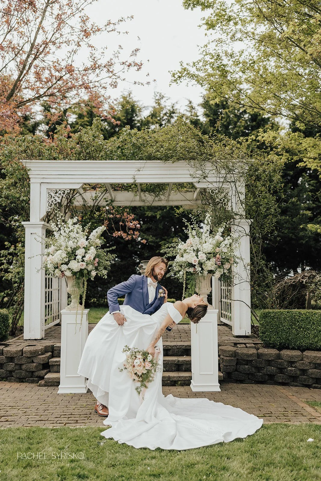 couple in ceremony space with tall floral arrangements