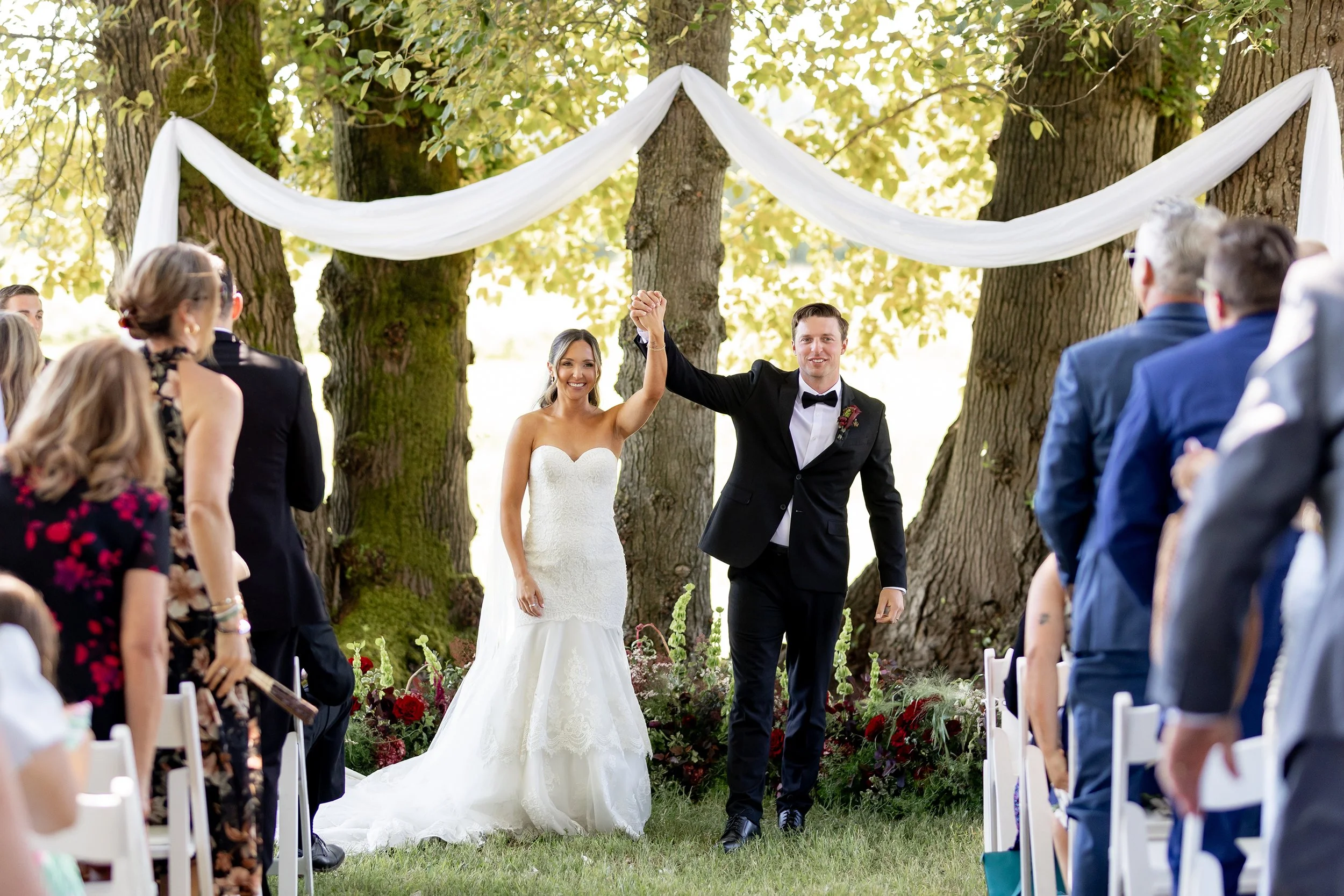 bride and groom in front of wine and lime colored florals