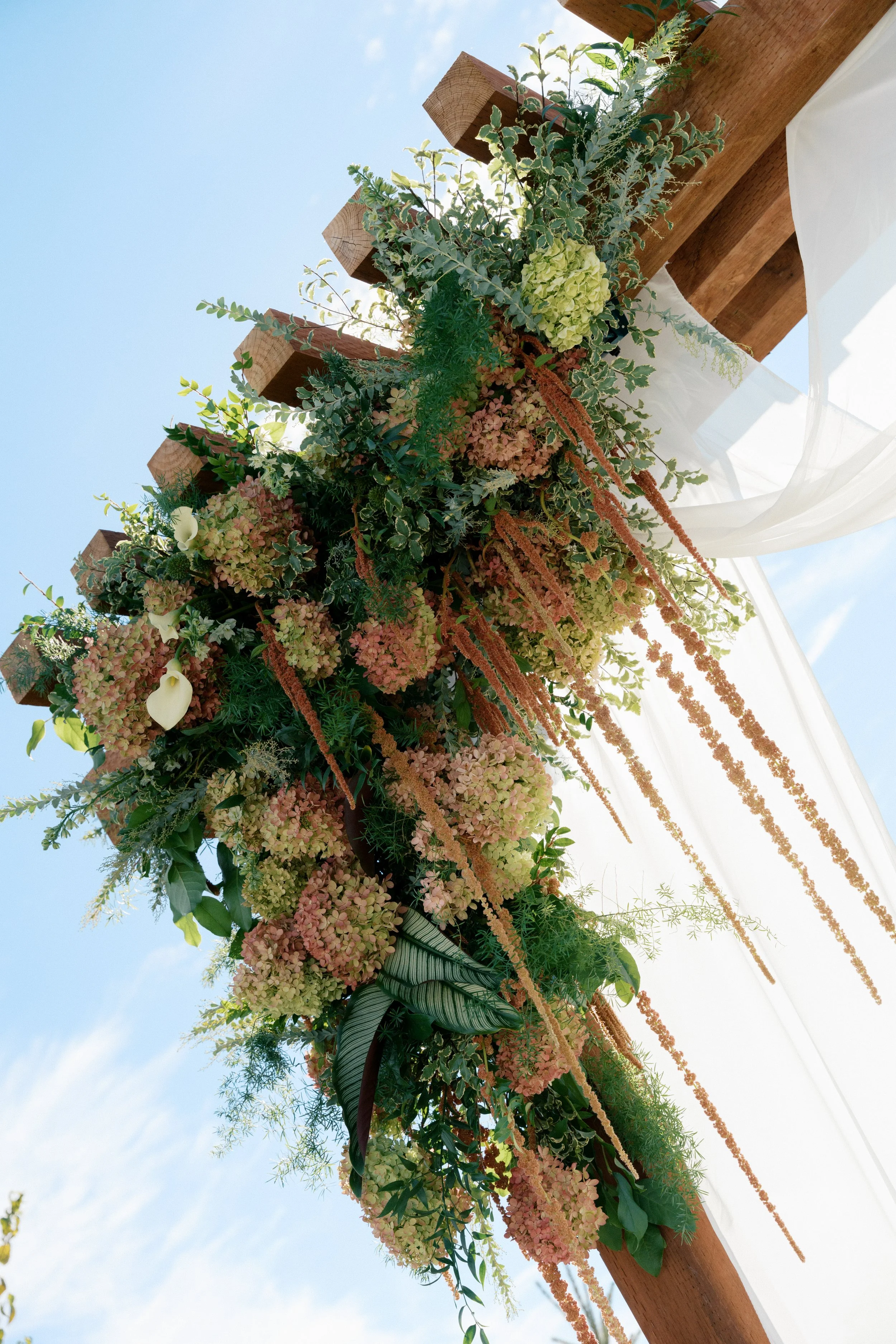 asymmetrical floral wedding arbor installation with hydrangeas.