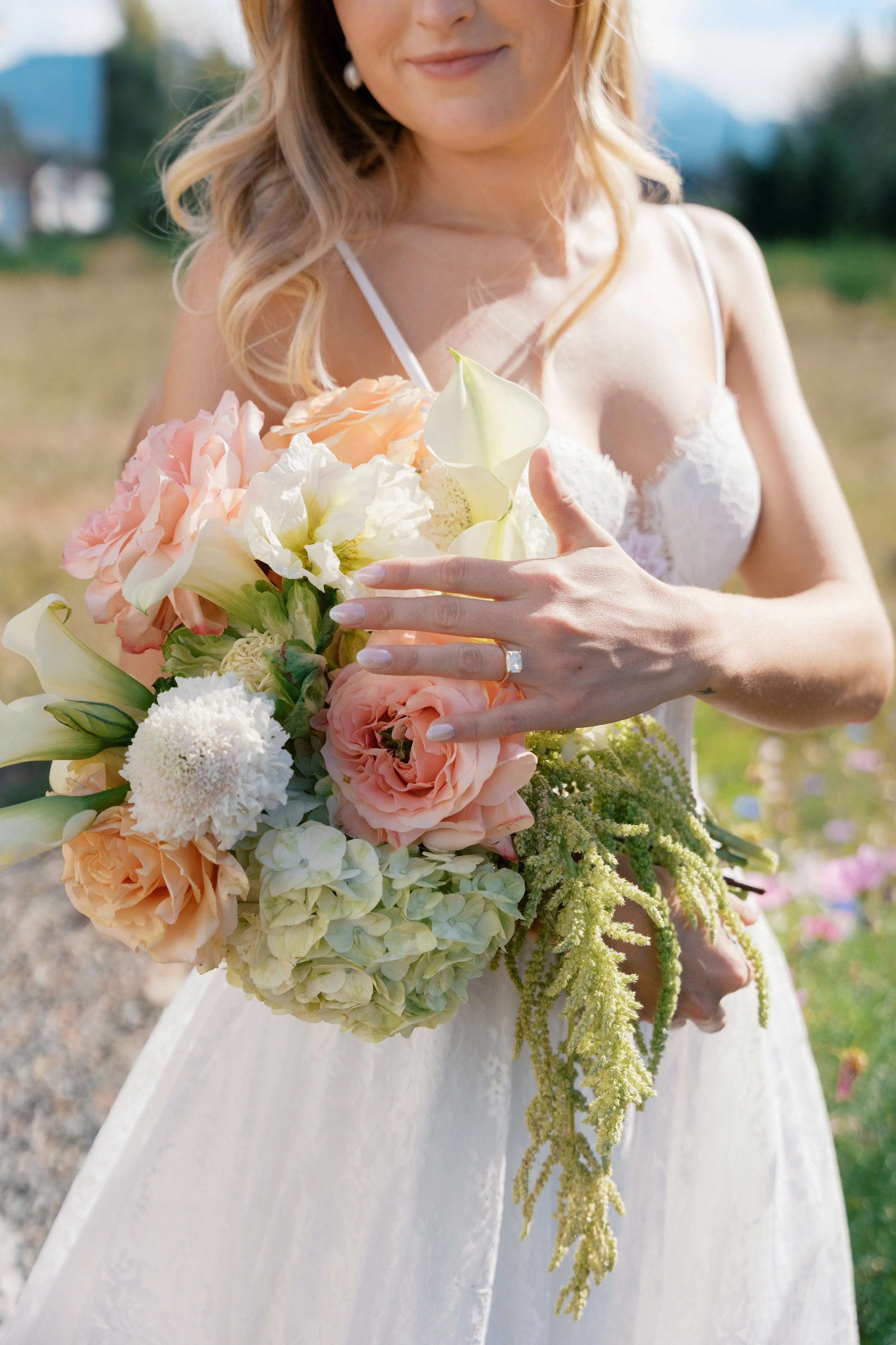 A bridal bouquet in peach, cream and green.