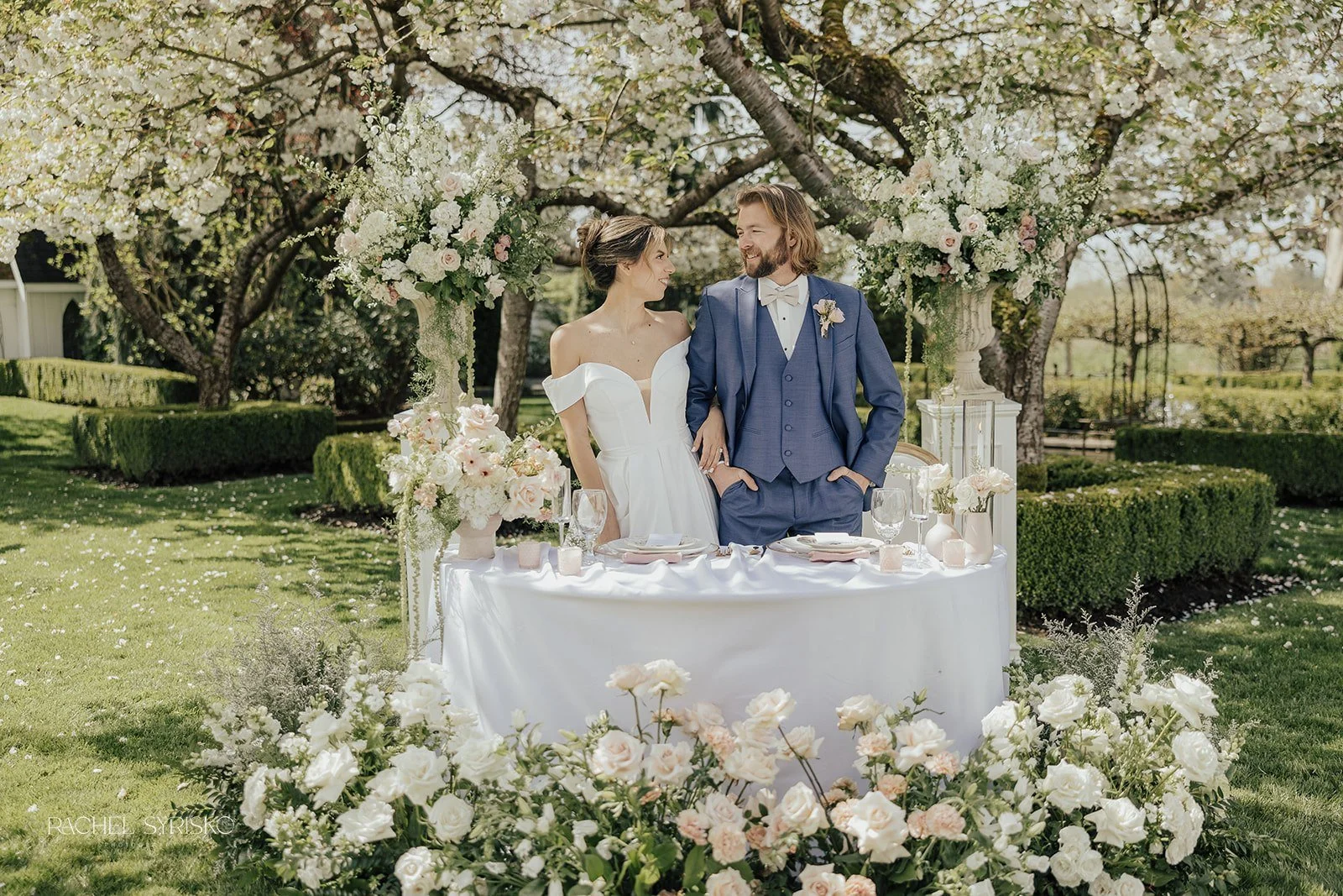 couple at sweetheart table under blossoming tree