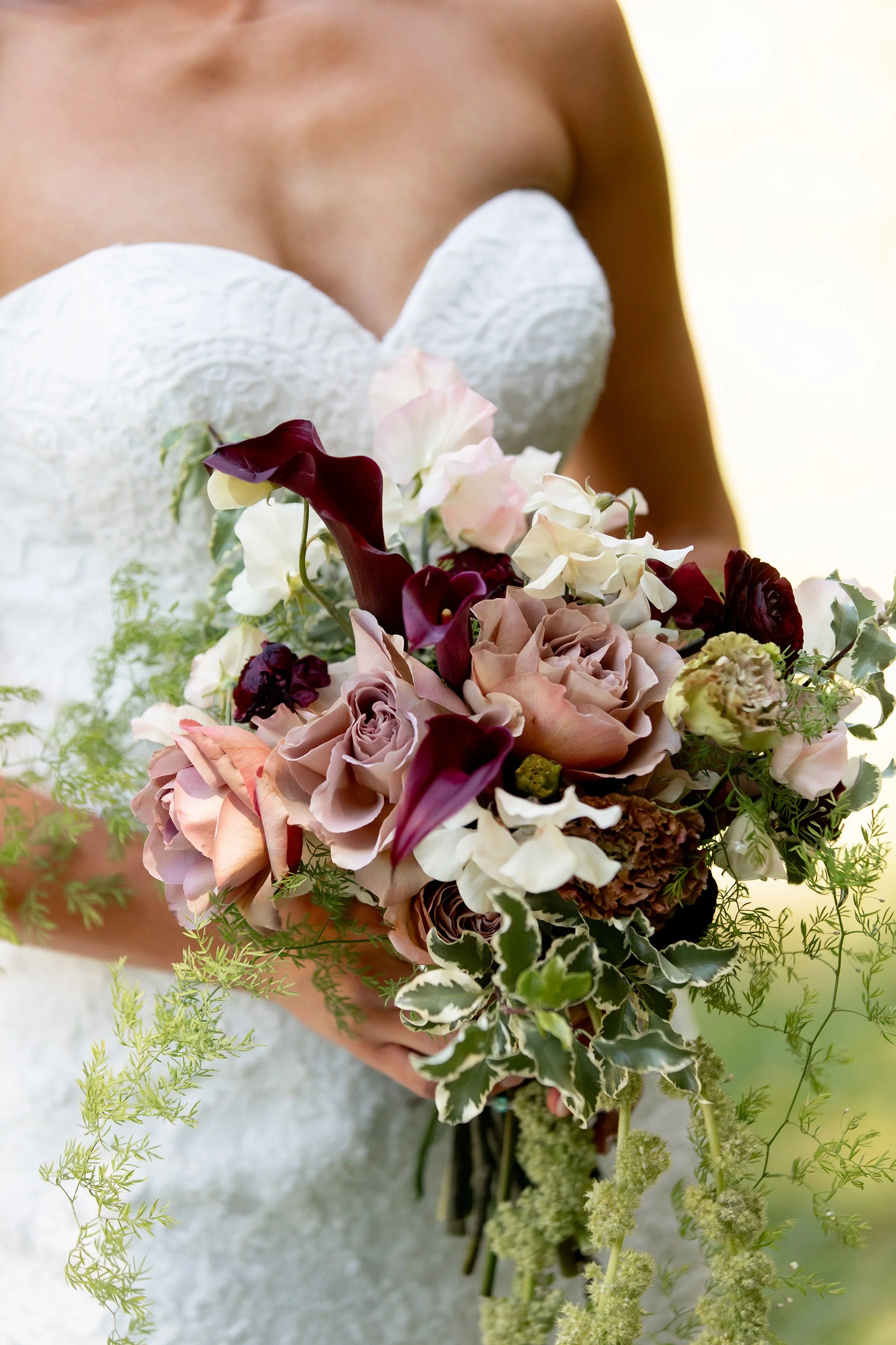 bouquet featuring mauve and wine colored blooms with draping green amaranthus