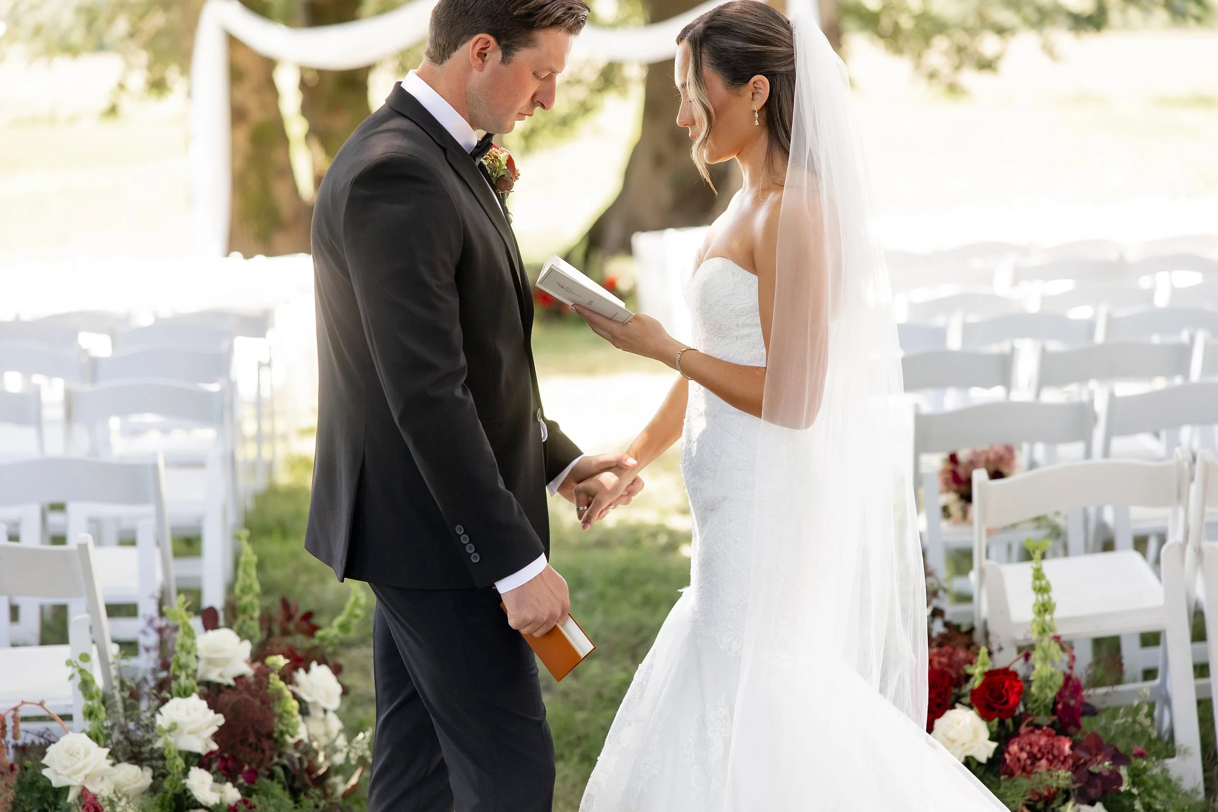 bride and groom exchanging vows in private, in front of floral arrangements