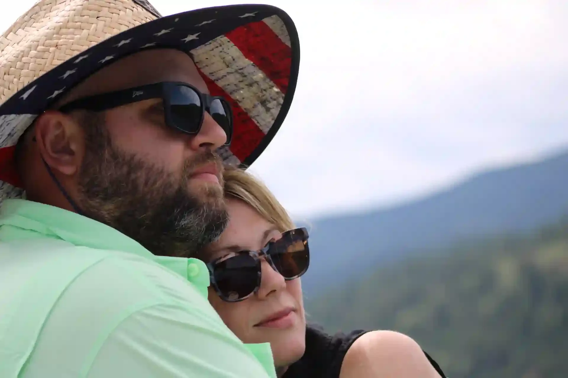 A couple in sunglasses, holding each other