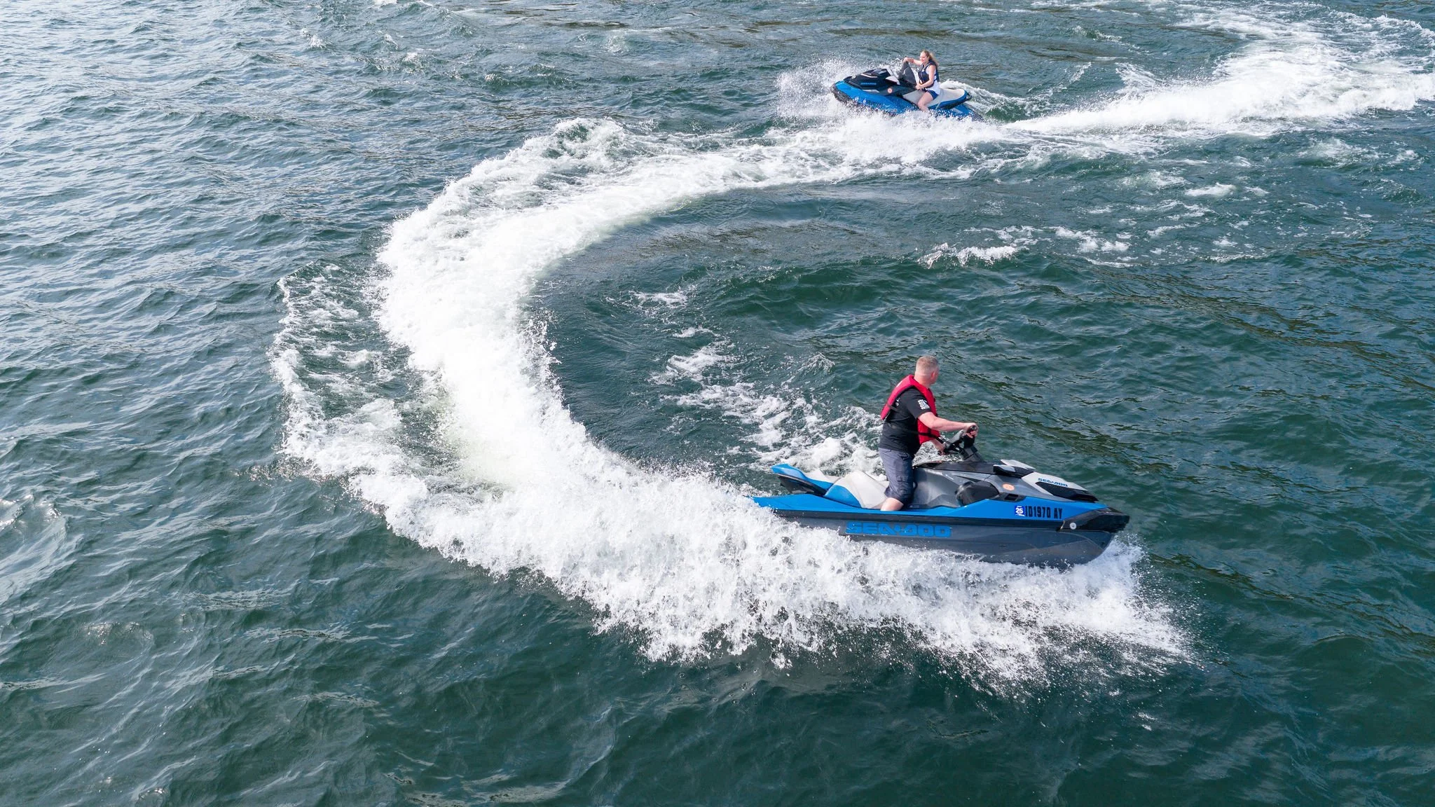 A father and daughter ride jet skis