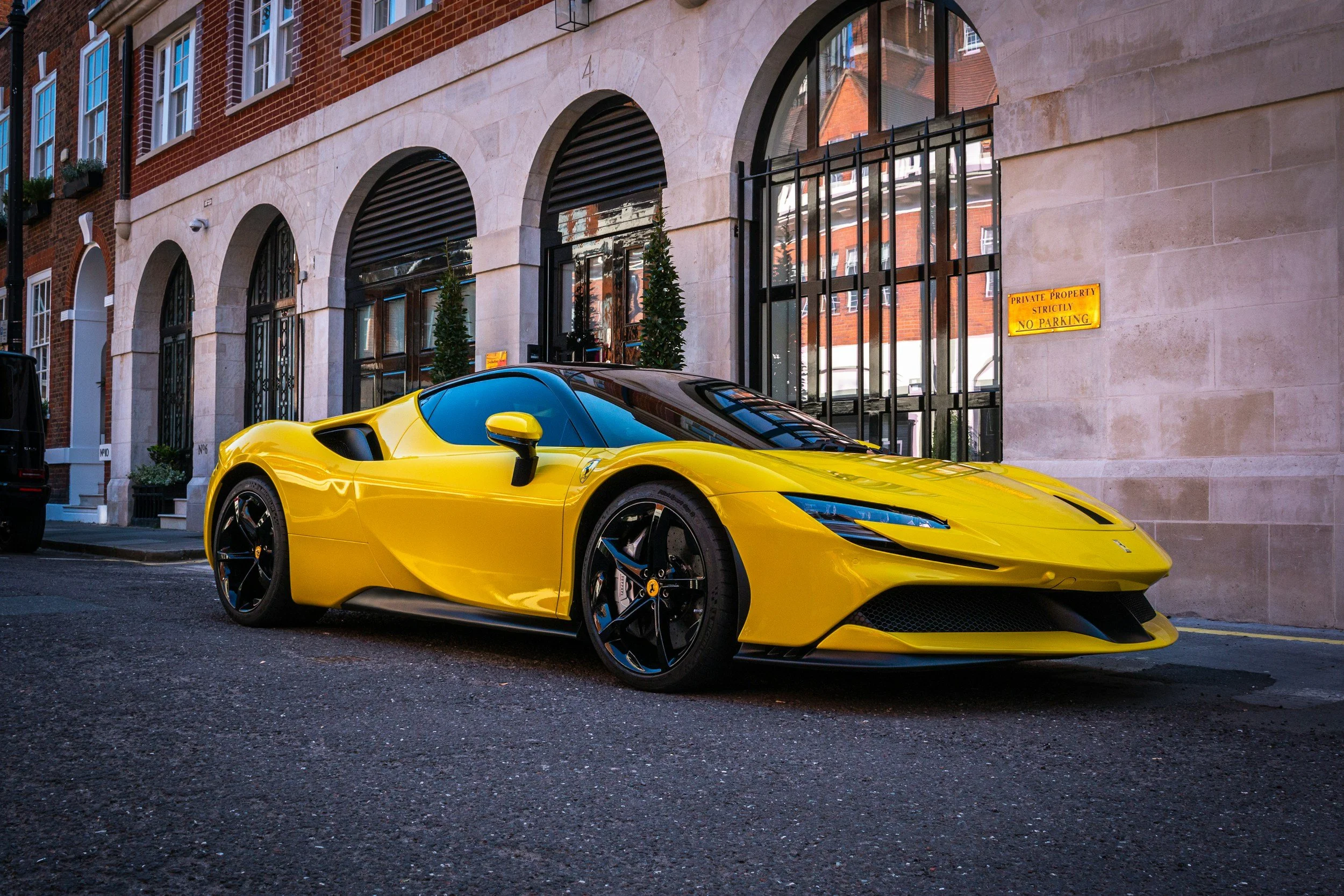 yellow sports car parked on road black wheels buildings on street