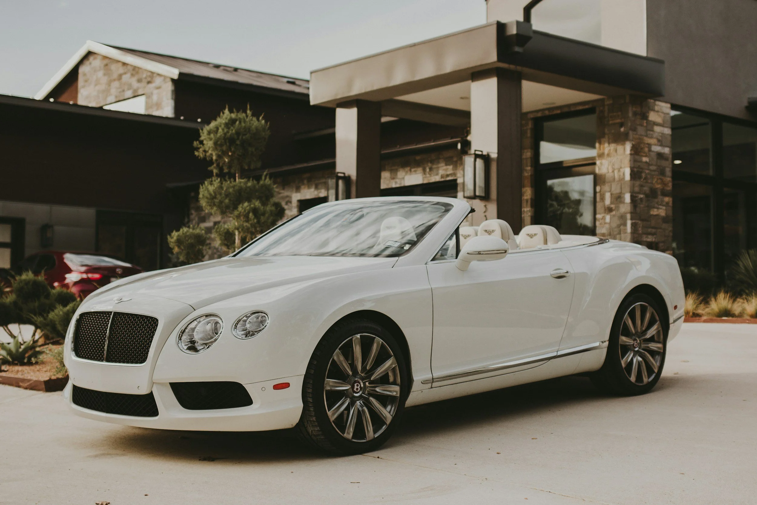 white convertible car parked in front of home driveway