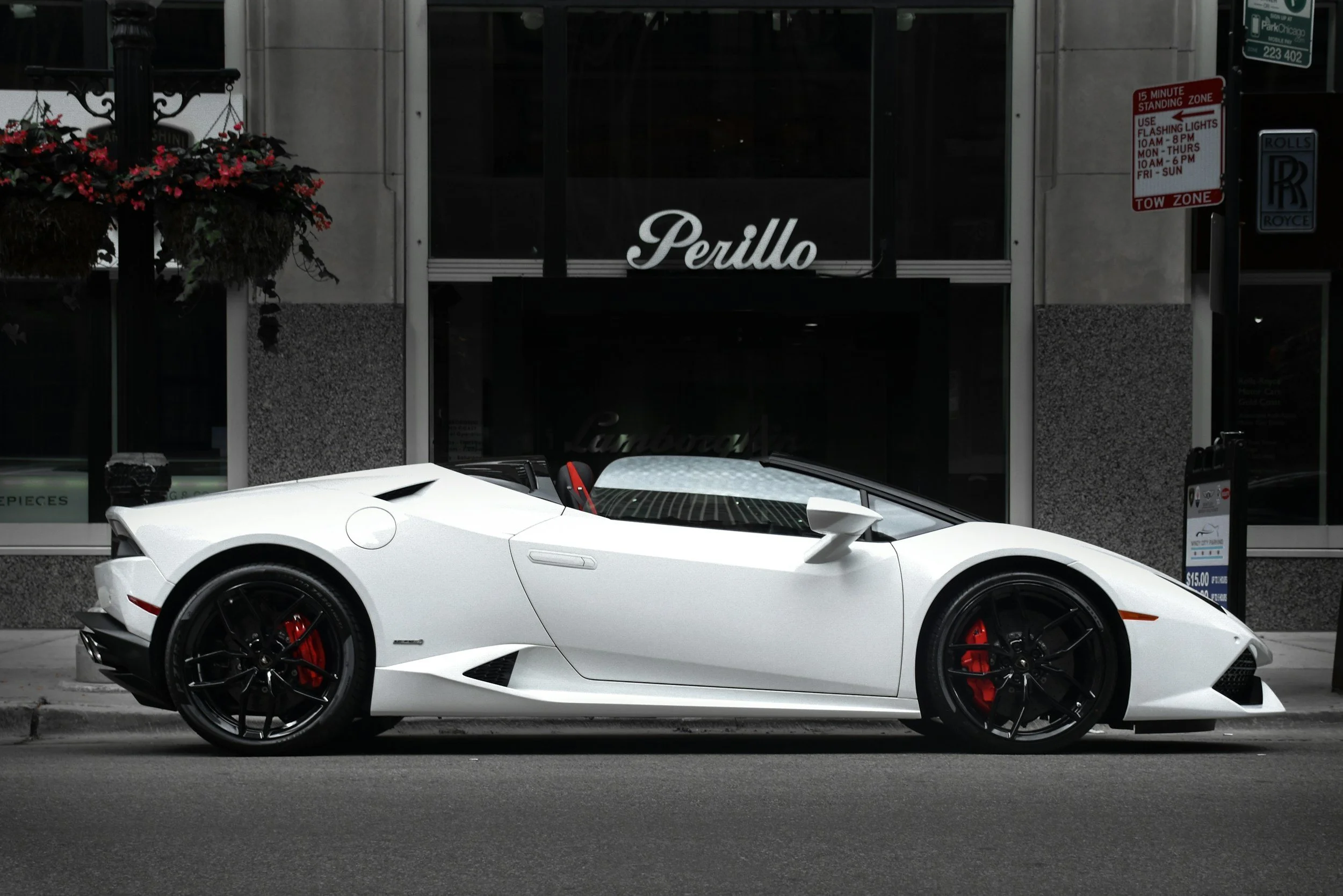 white 2 door convertible car parked downtown in city next to a high end store front