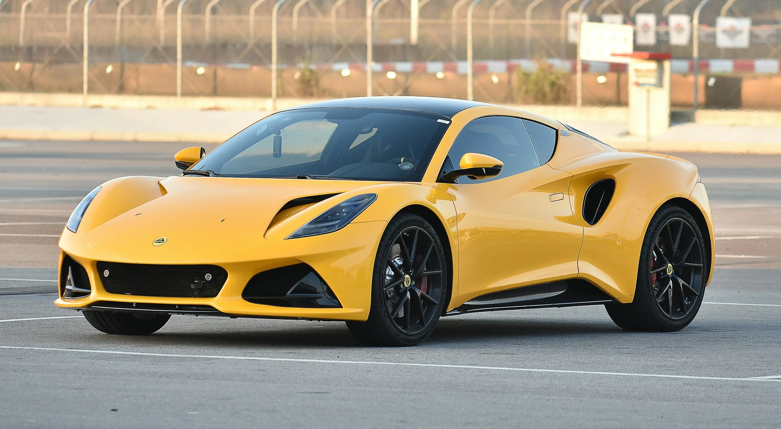 yellow car black wheels racing on cement going around corner