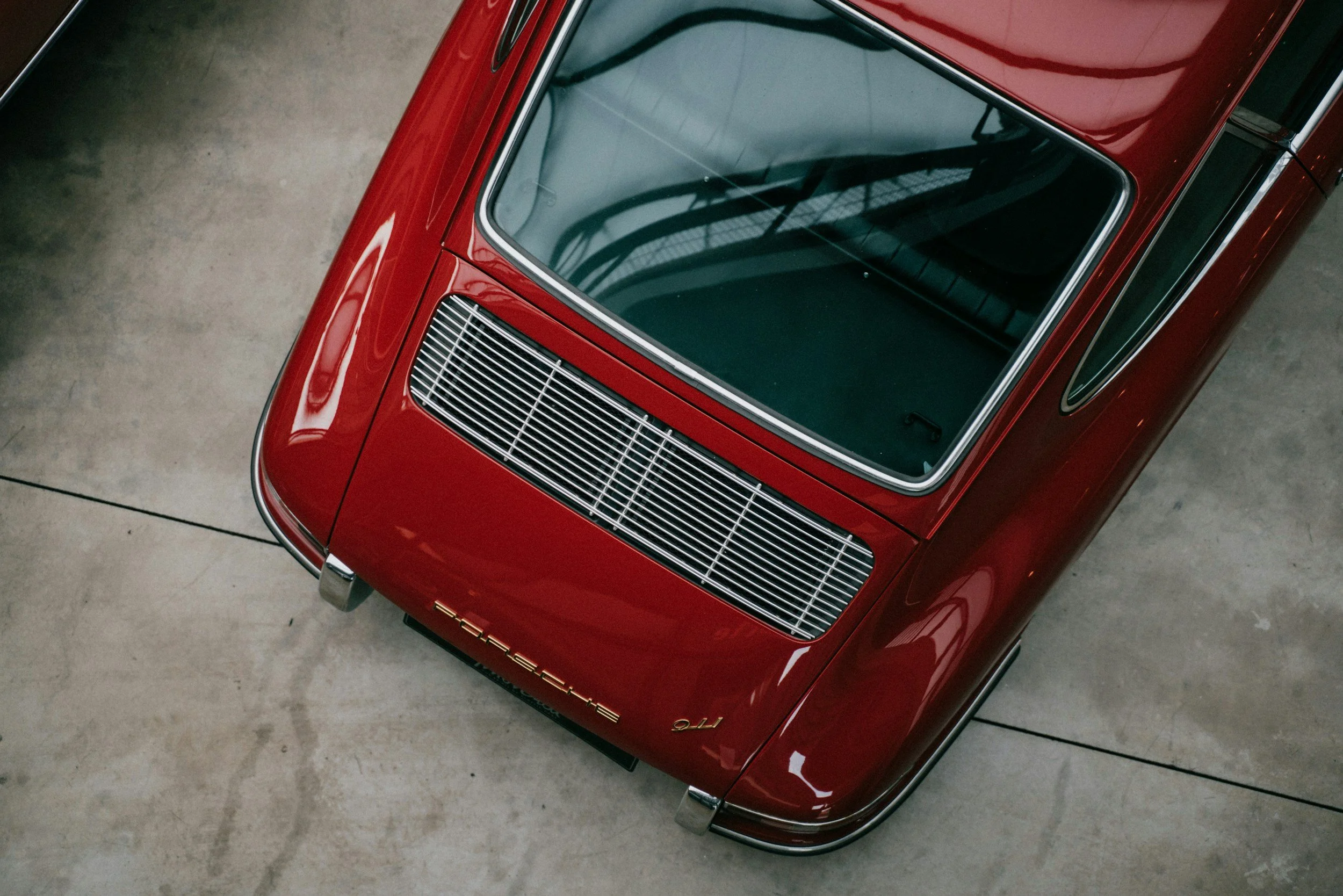 classic older sportscar 2 door red in color gold emblems