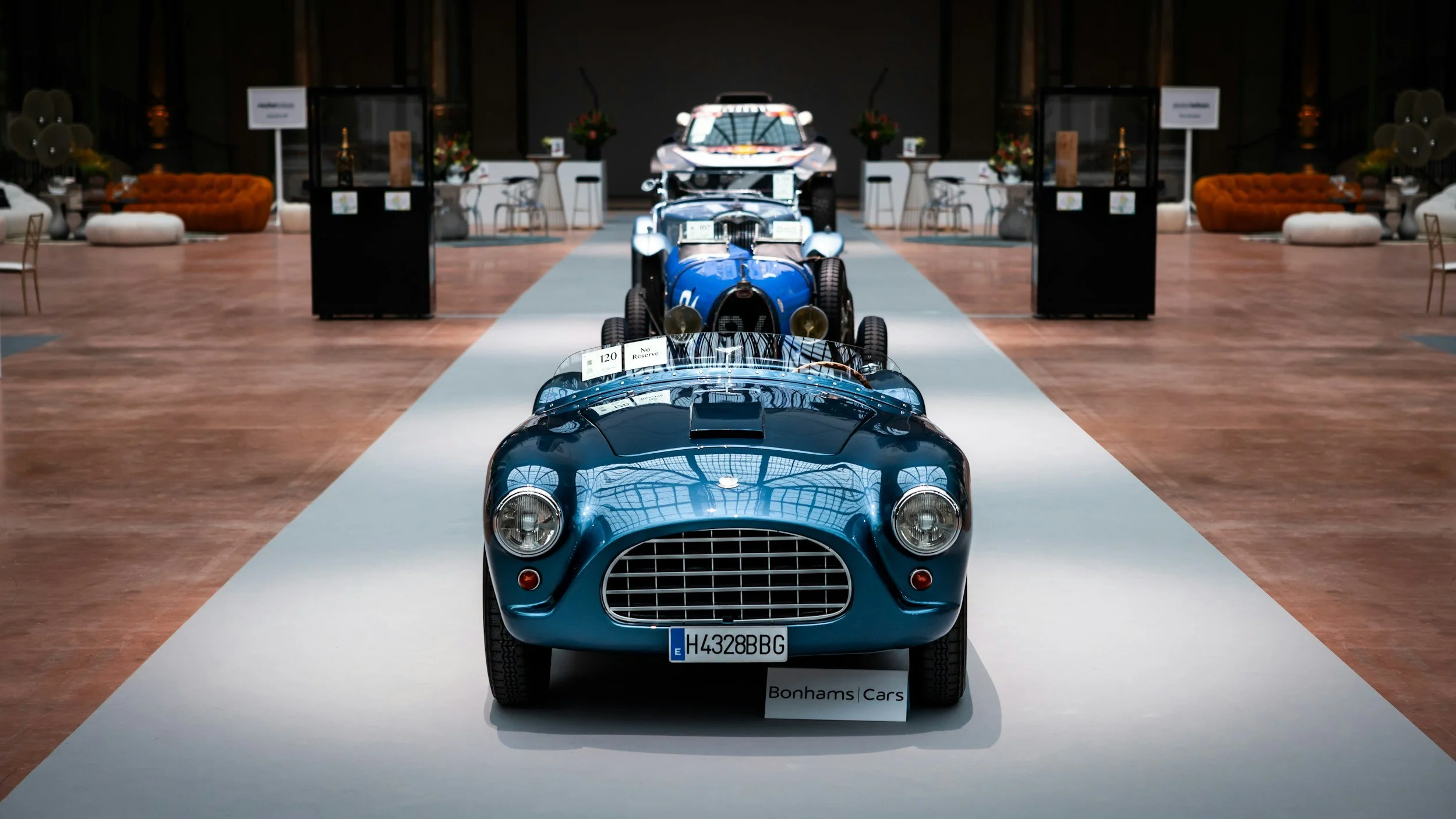 2 BLUE CARS 2 WHITE CARS IN A ROW AT CAR AUCTION ON WHITE FLOOR