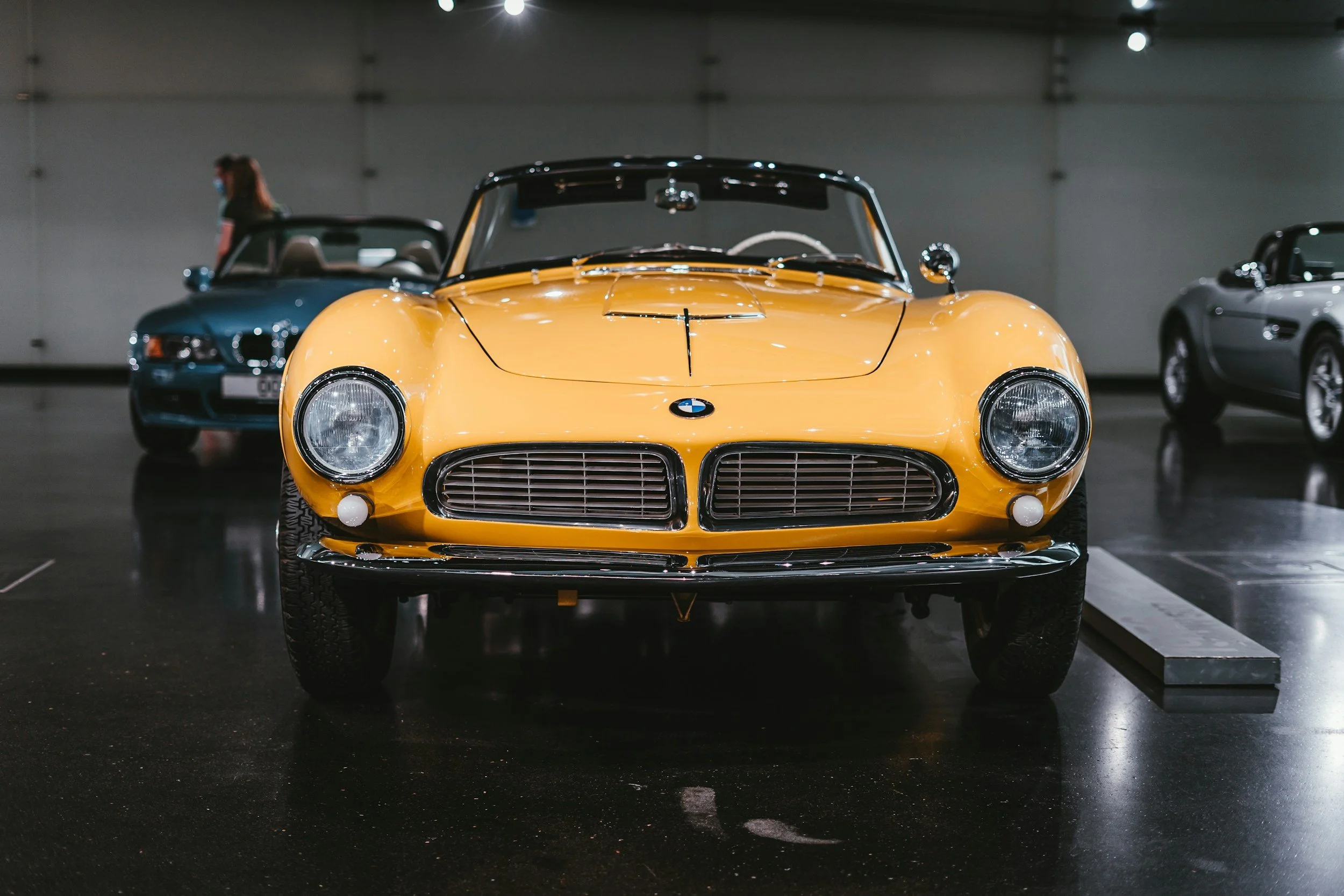 YELLOW CAR AND BLUE CAR IN SHOWROOM FOR AUCTION