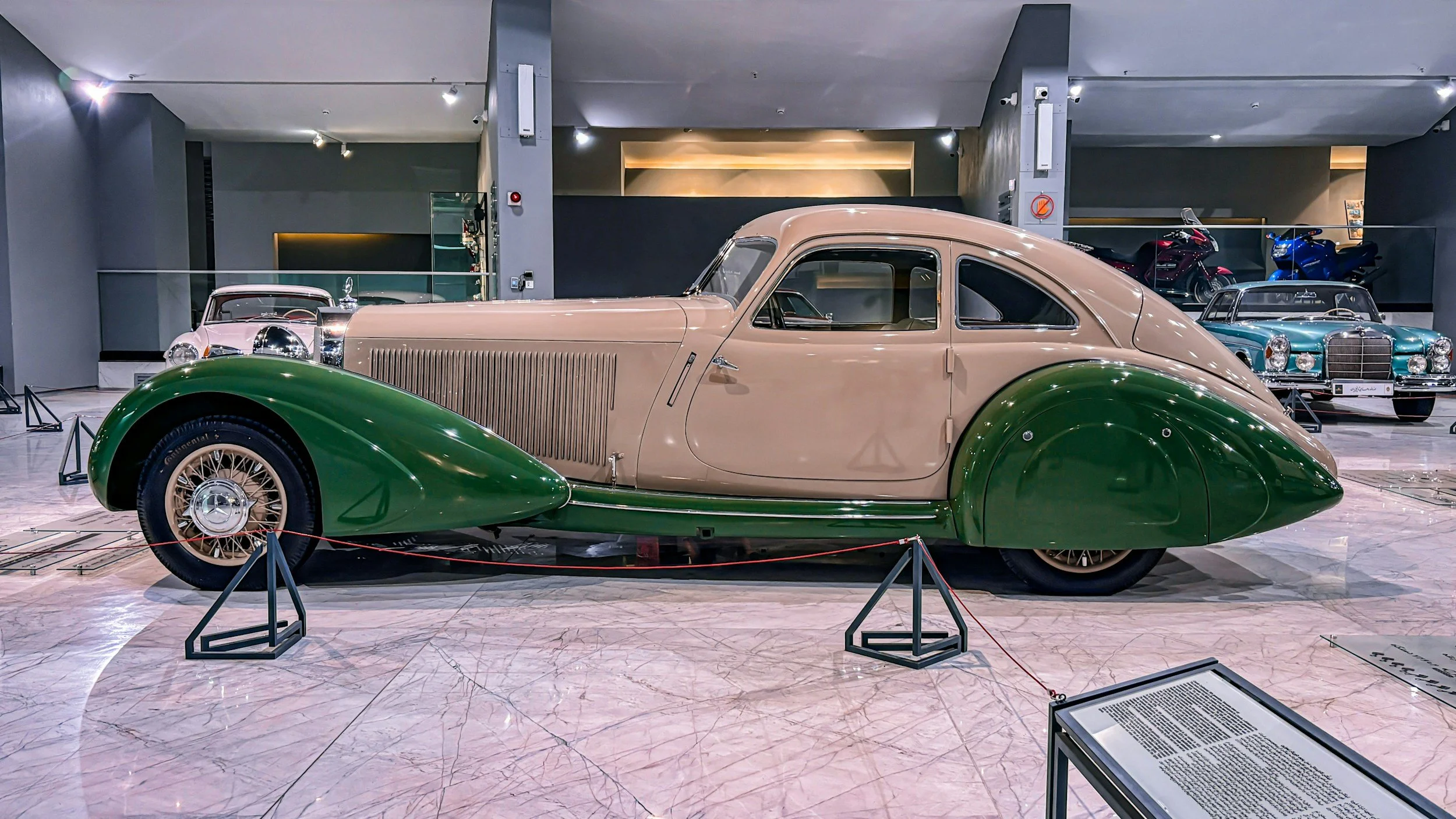 GREEN AND TAN CAR IN SHOWROOM AUCTION
