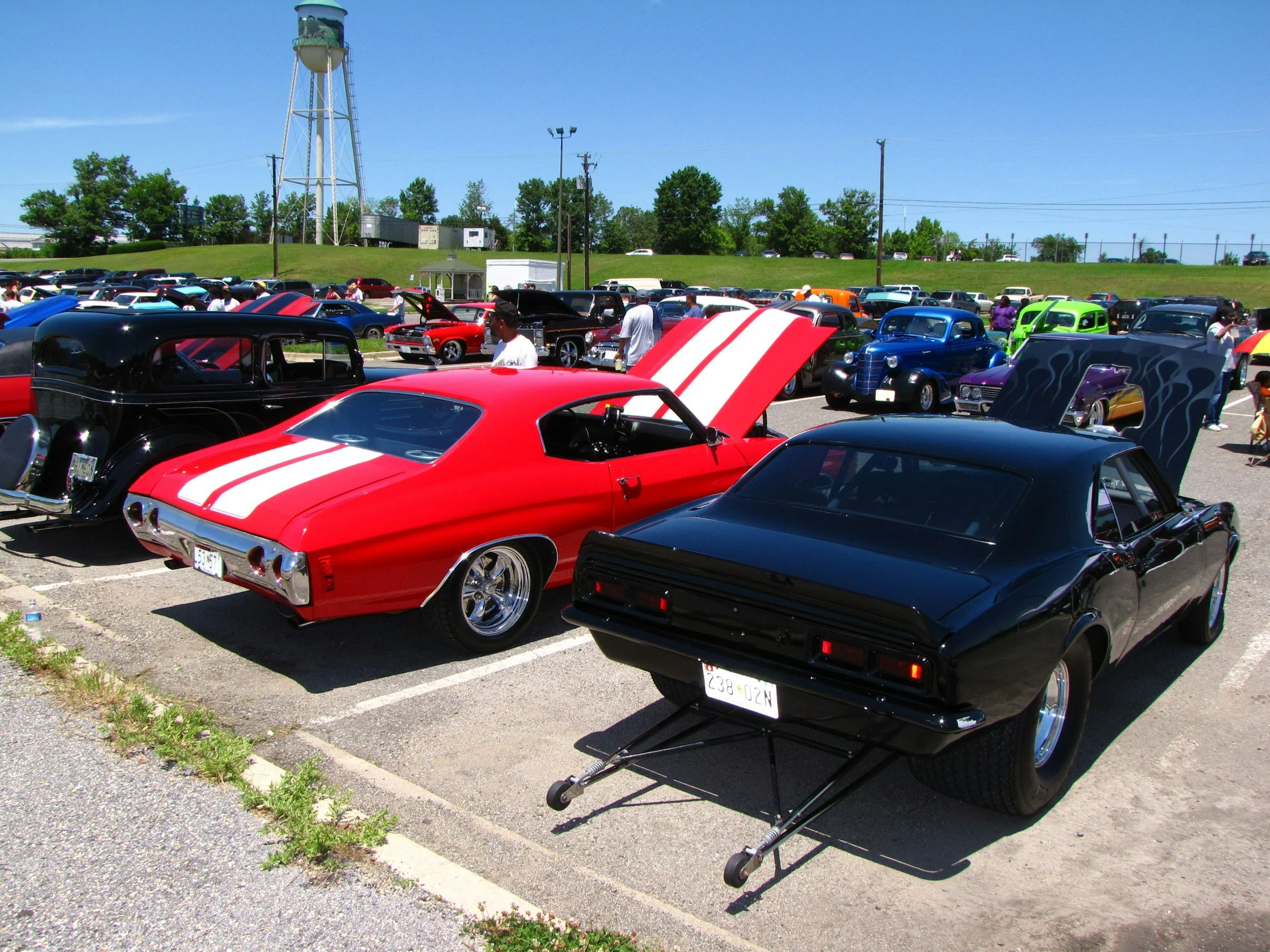 2 old classic chevell cars black red hot rods at car show