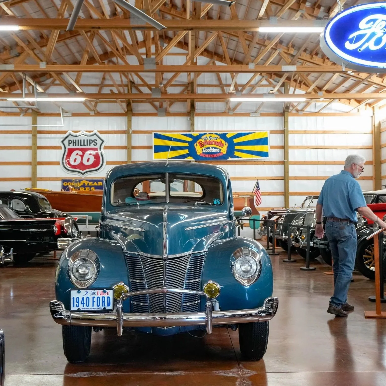 blie 4 door classic sedan with show cars in background inside a large pole building with pnw car smart