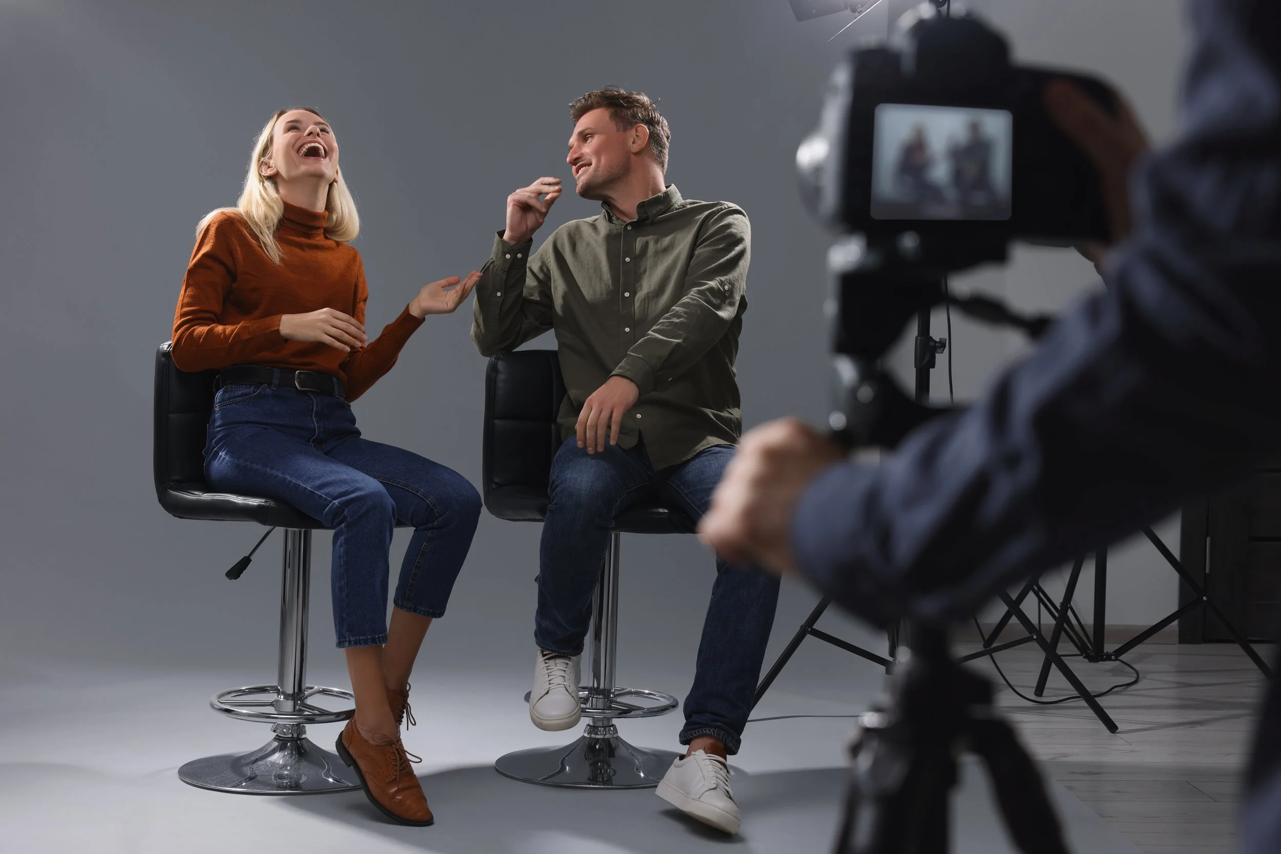 2 people laughing being interviewed with camers