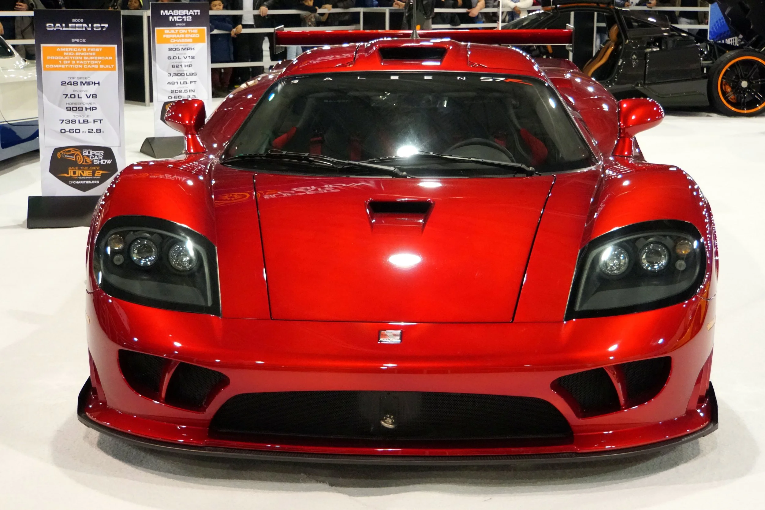 red sportscar sitting in a car show displayed