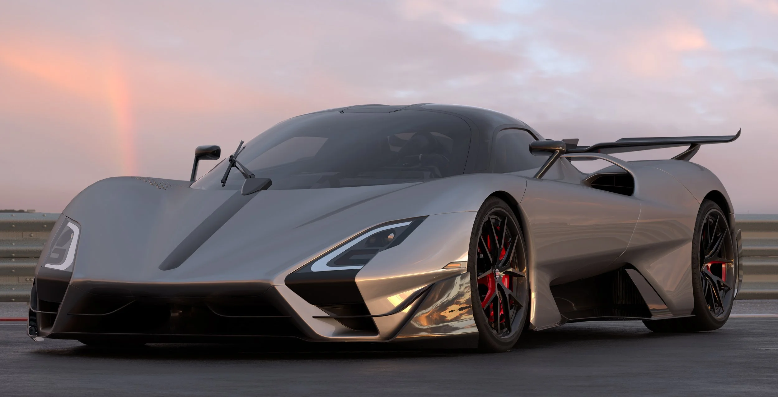 silver car parked on cement showing sleek body with rear wing on back