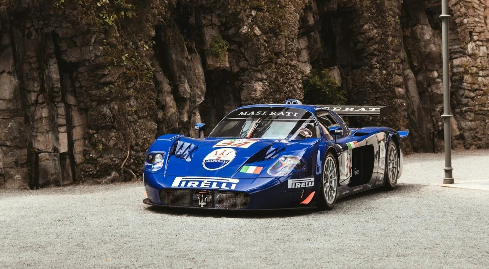 blue race car with stickers on it parked ready for pictures