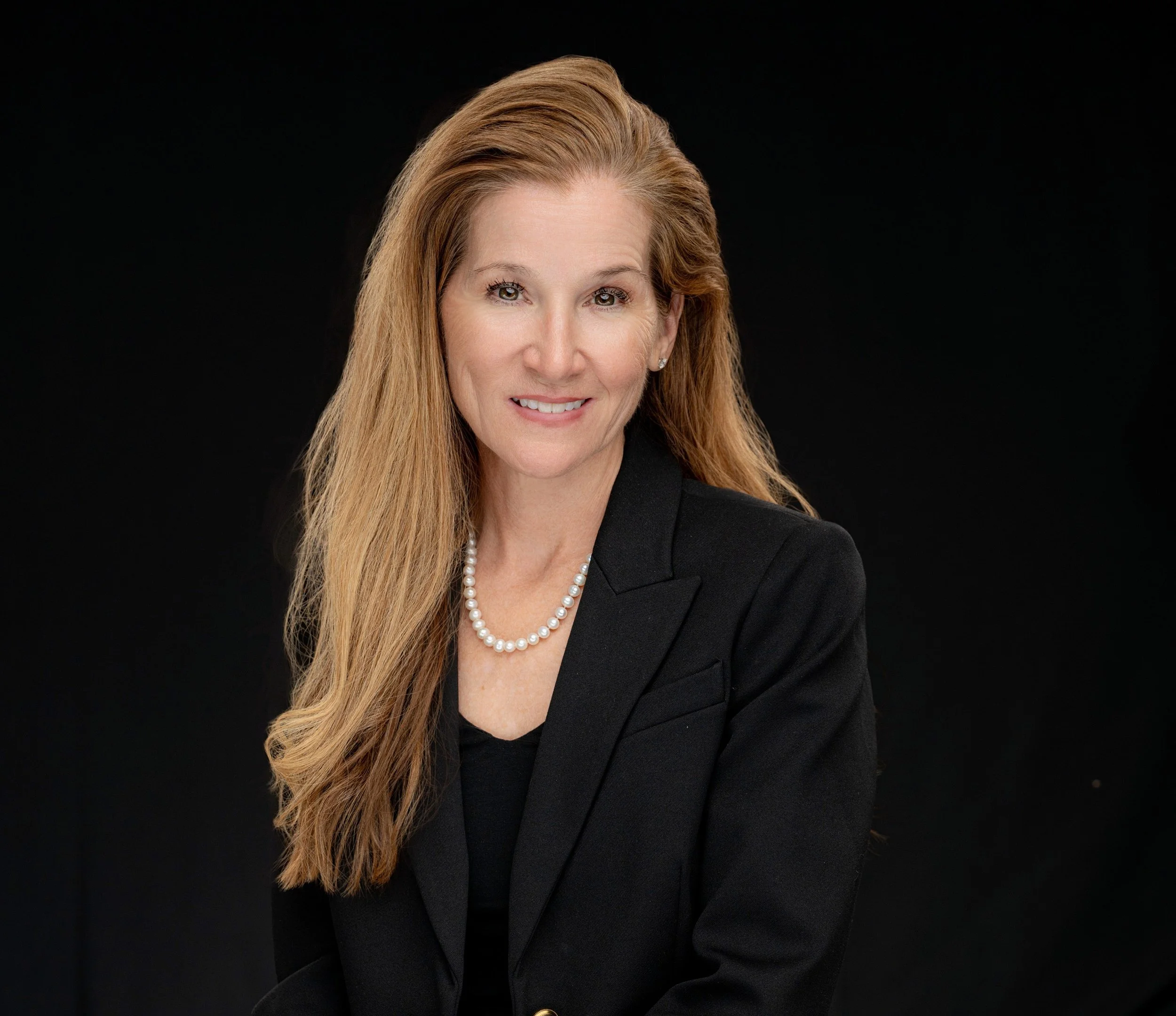 Woman in paisley shirt with yellow lanyard at a symposium