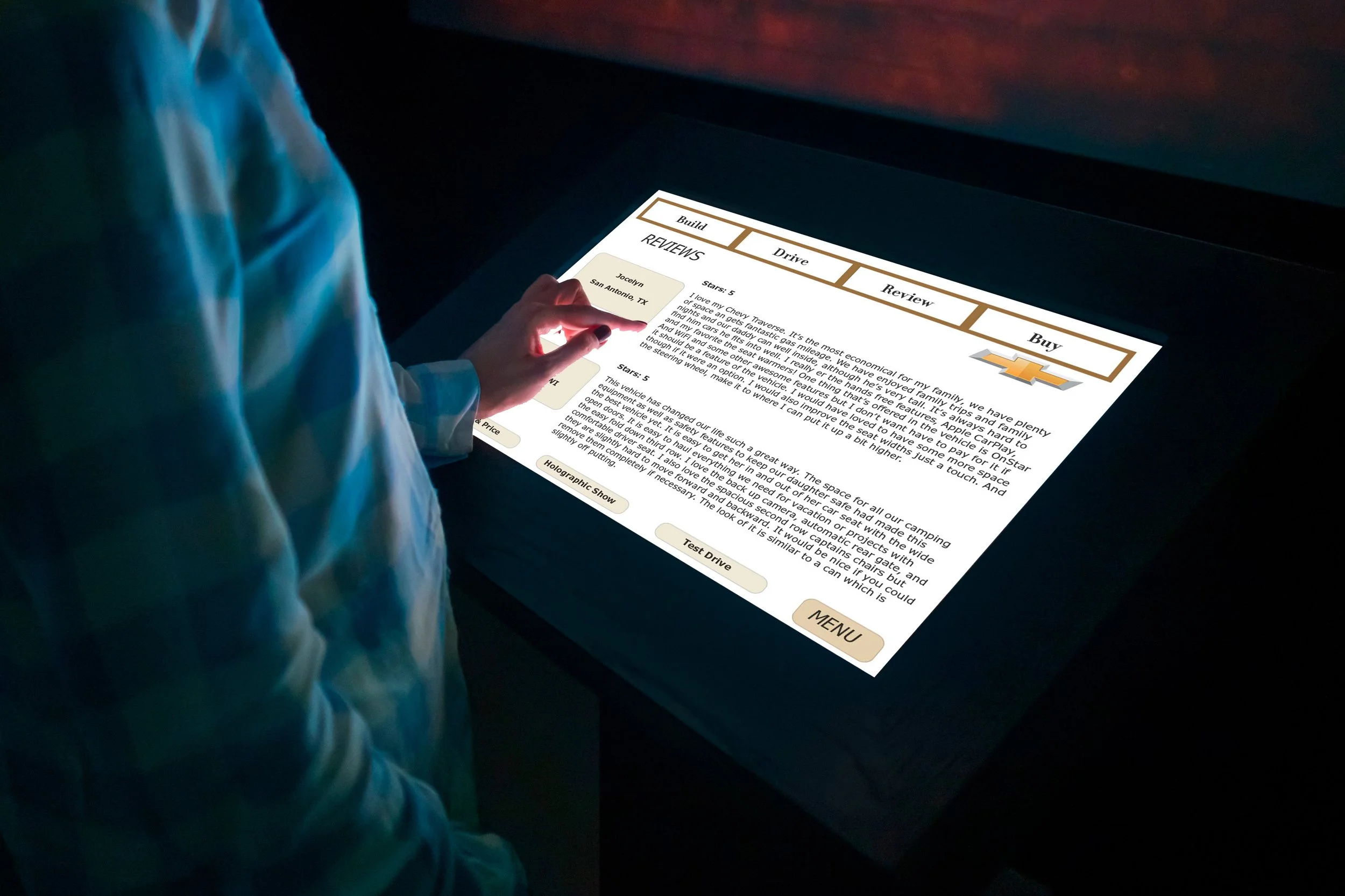 Person dressed in a turquoise jacket using a touchscreen tablet displaying reviews and options related to vehicles, with a dark background.