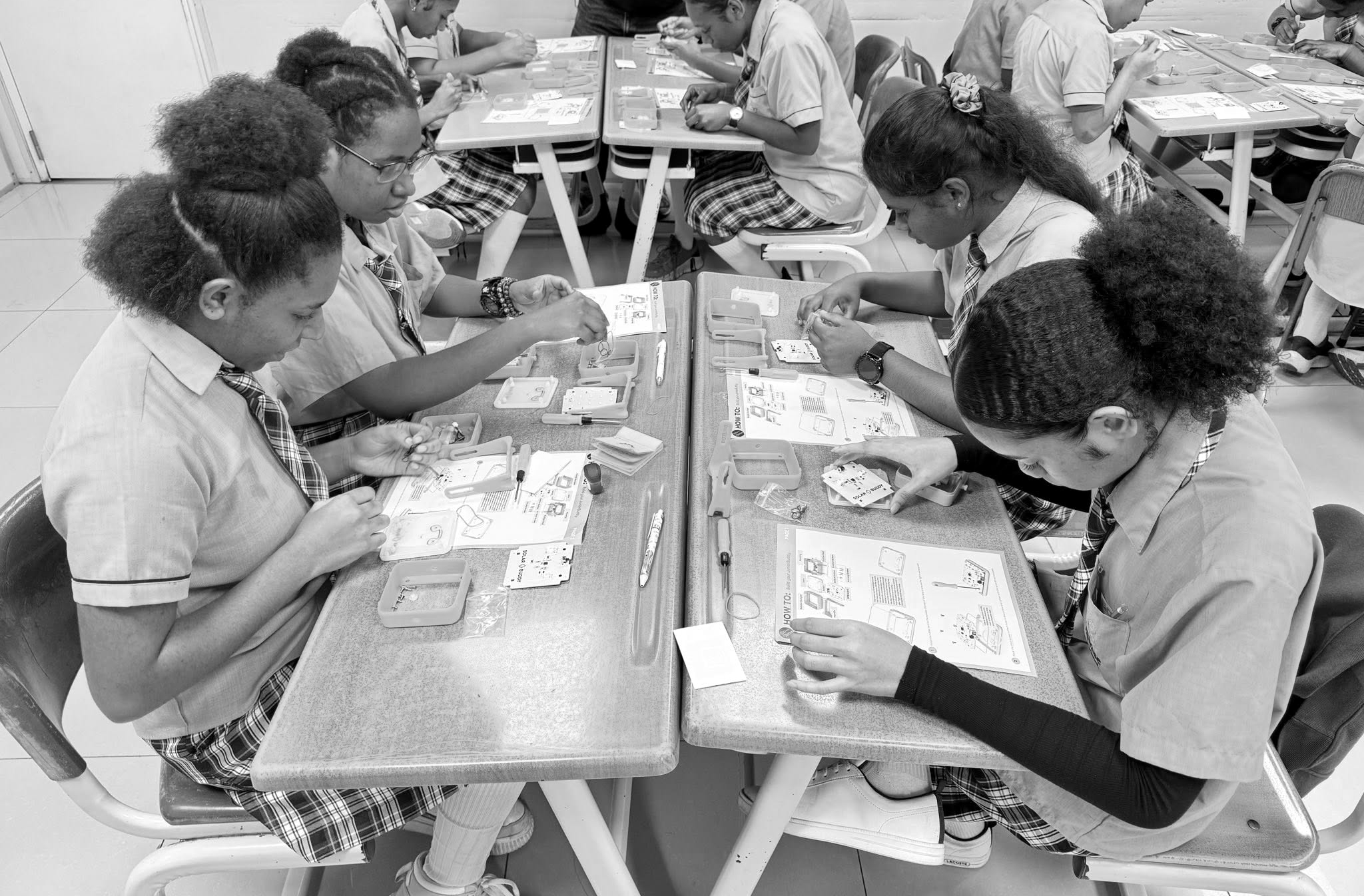 A group of girls engaged in hands-on STEM learning as they assemble solar lights, highlighting gender equity in STEM education and pathways toward tech careers for women