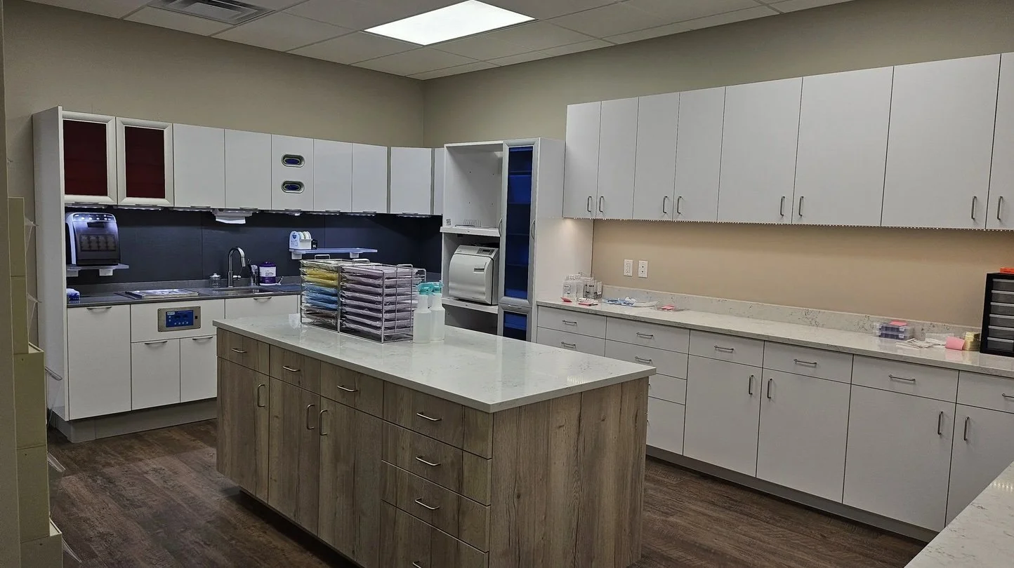 Empty hospital or medical clinic kitchen with cabinets, countertop, and storage areas.